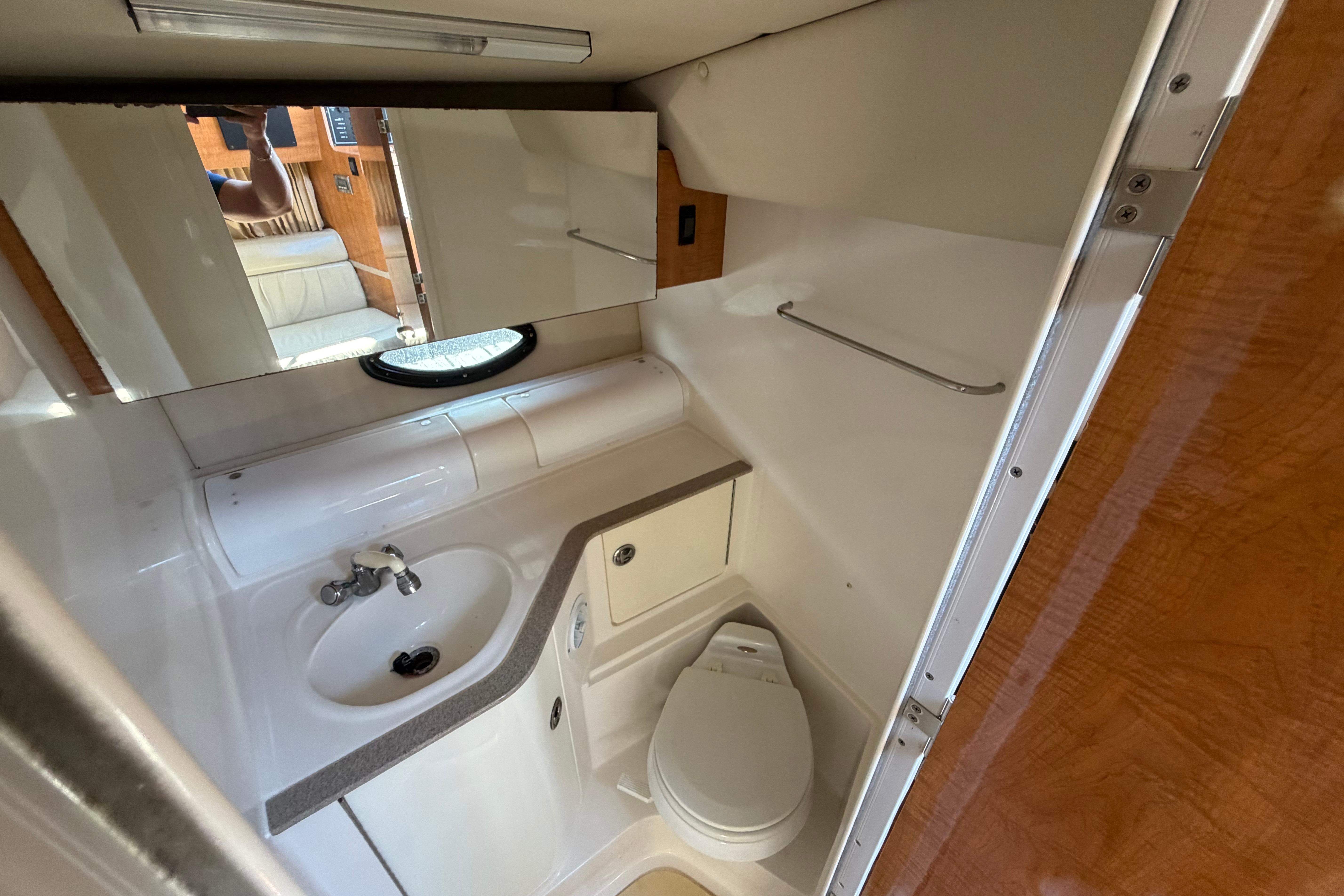Bathroom interior of 2003 Regal Commodore 3260 yacht, featuring sink, toilet, and mirror.