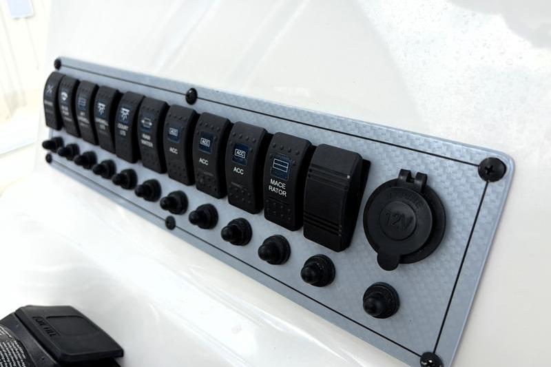 Control panel of 2024 Key West 239 FS boat with multiple switches and outlets.