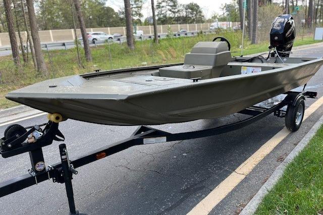 2026 Tracker Grizzly 1648 SC boat on trailer, parked on roadside.