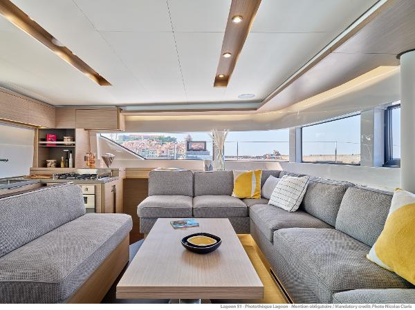 Luxurious interior of 2025 Lagoon 51 ICONIC yacht with modern seating and panoramic windows.