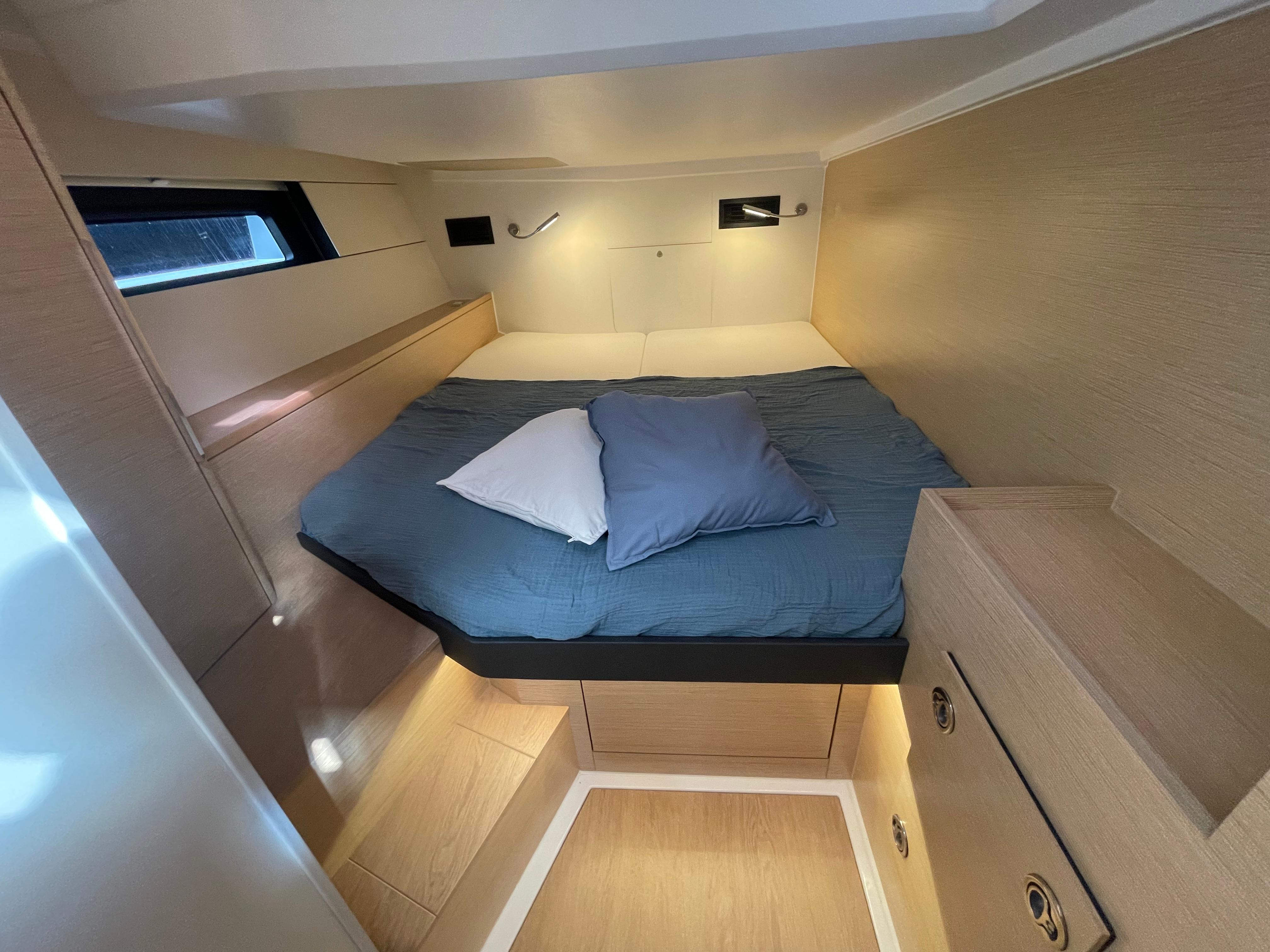 Cozy cabin interior of 2023 Hanse 460 yacht with bed and storage.