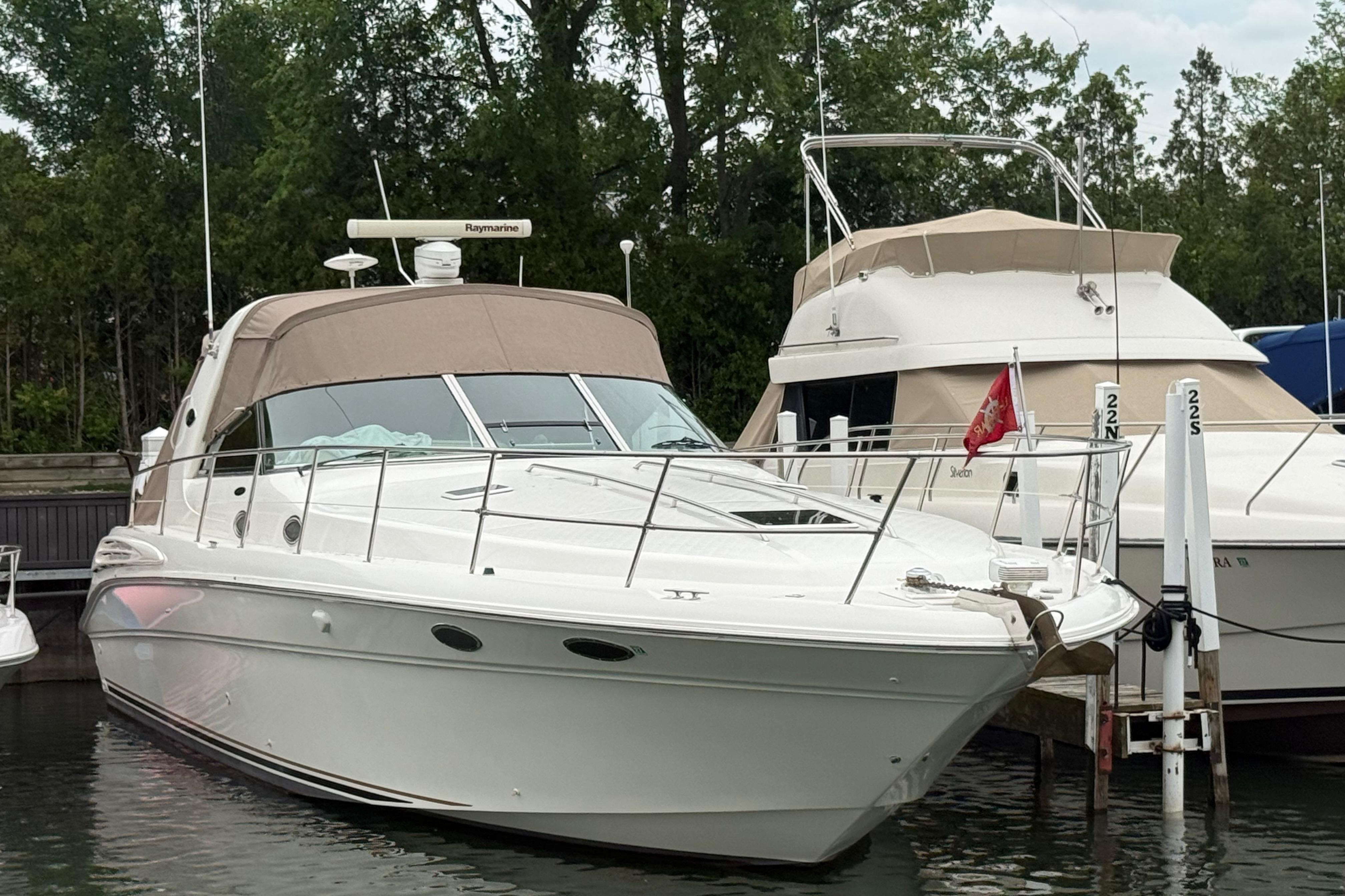 1998 Sea Ray Sundancer 400 yacht docked in a marina, surrounded by trees.