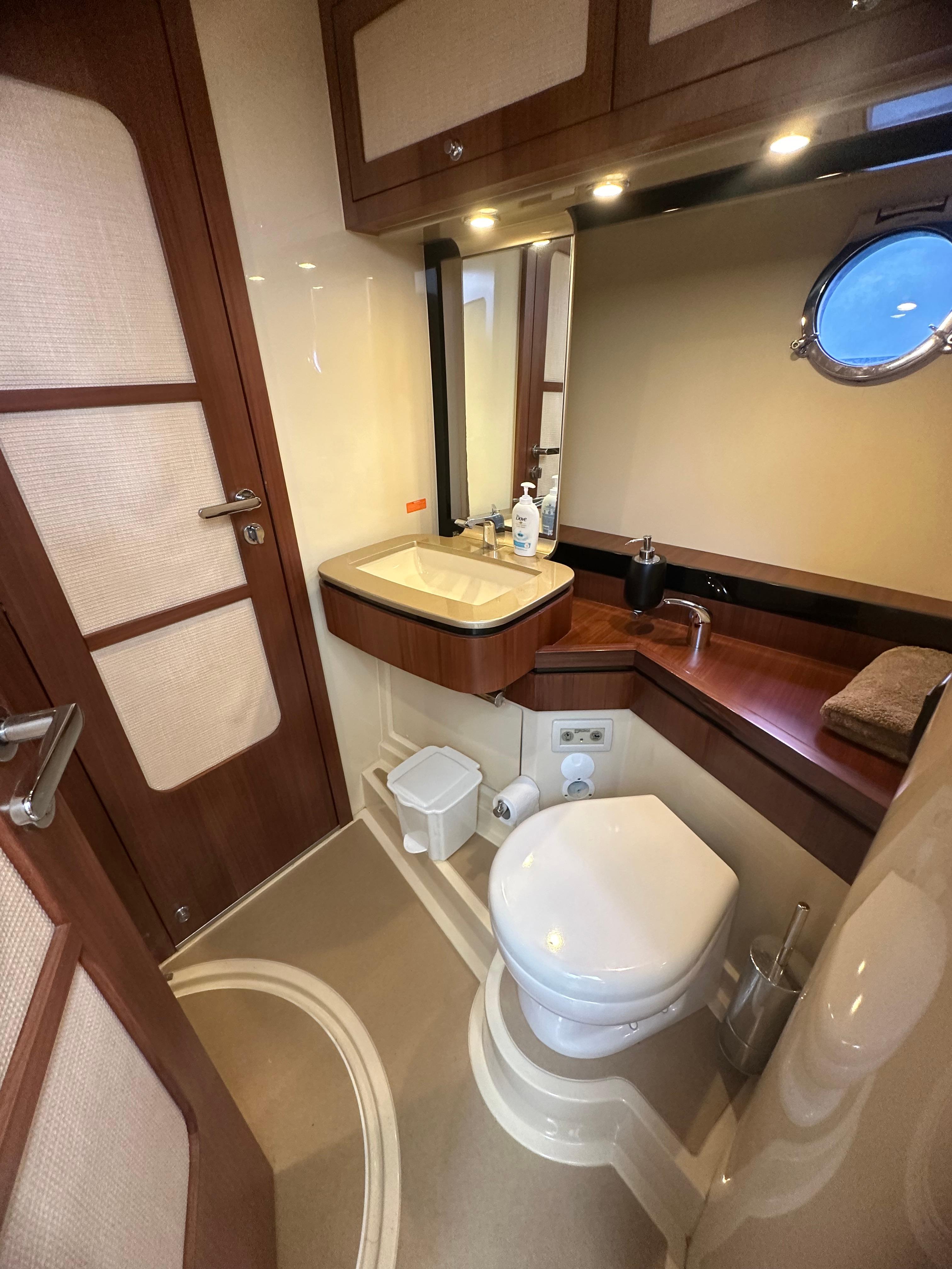 Luxurious 2014 Azimut Magellano 50 yacht bathroom with modern fixtures and elegant wood accents.