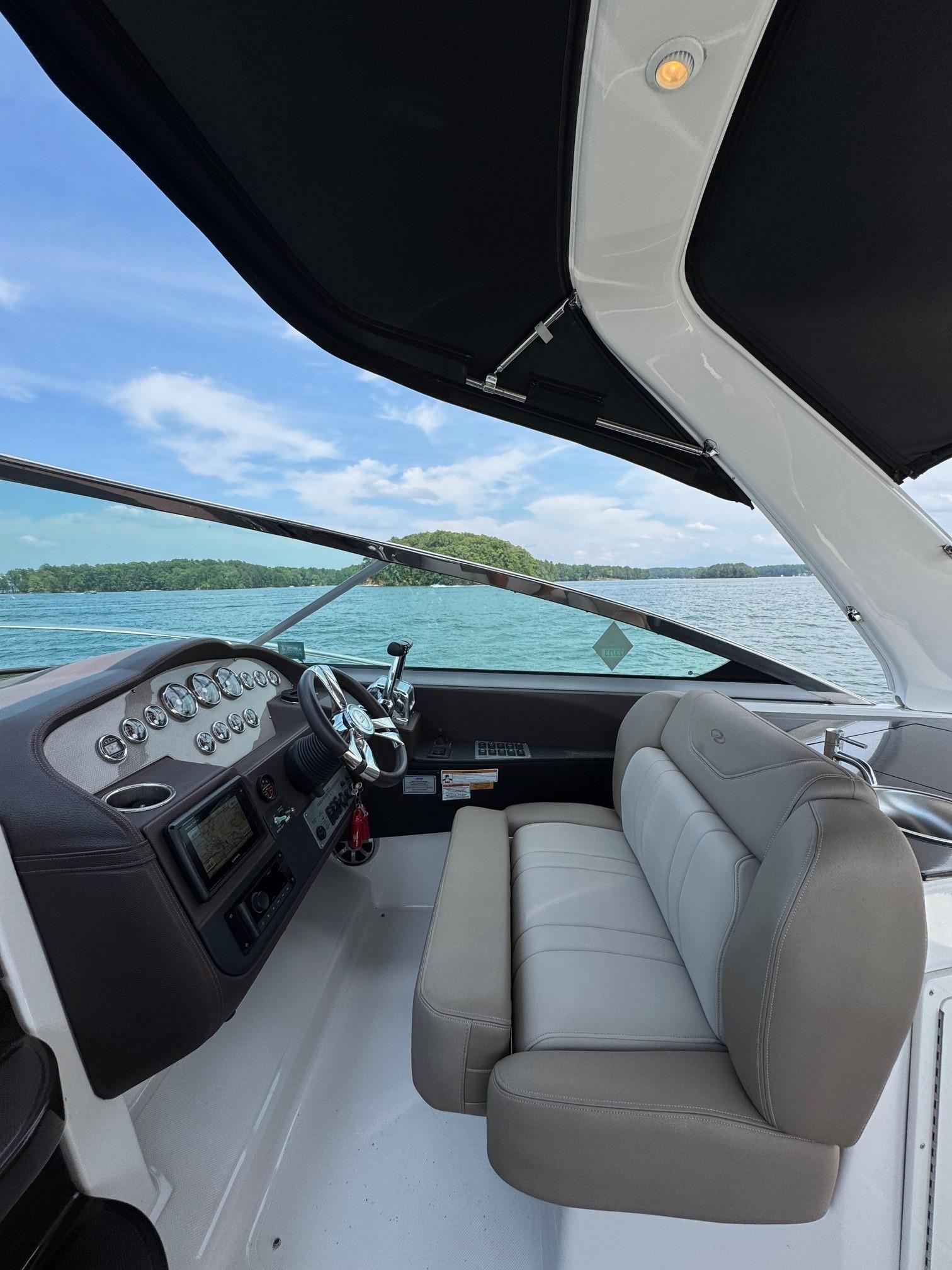 2014 Regal 32 Express boat interior with steering wheel and seating, on a sunny day.
