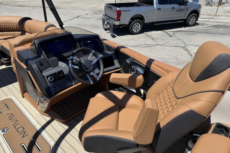 Luxurious interior of 2026 Avalon Excalibur LTD Quad Lounge boat with plush seating and modern dashboard.