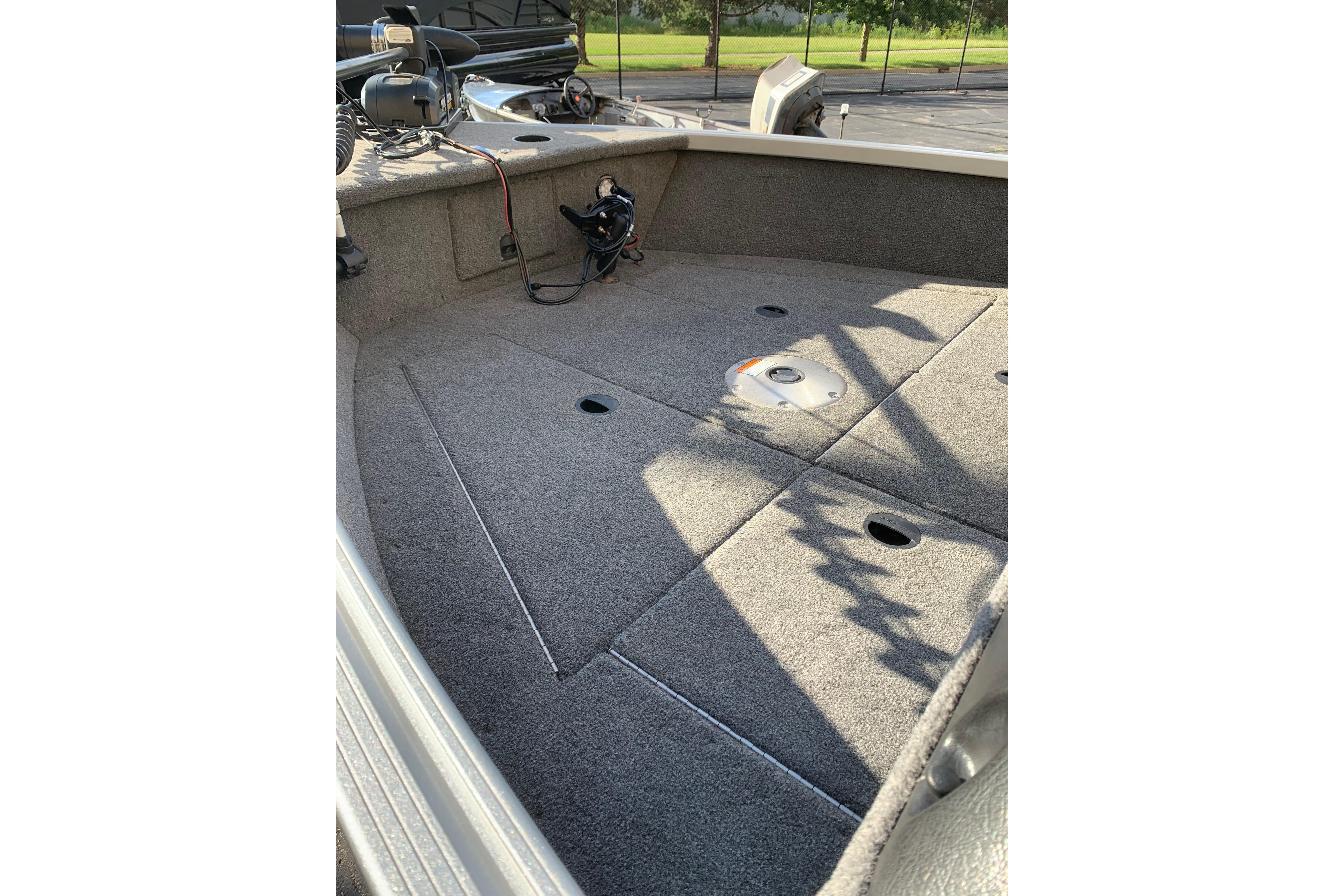 1993 Alumacraft Trophy 175 boat interior with carpeted deck and fishing equipment.