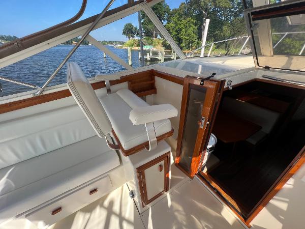 The image shows the cockpit of a 1985 Viking 35 Express with white seating and wood accents.
