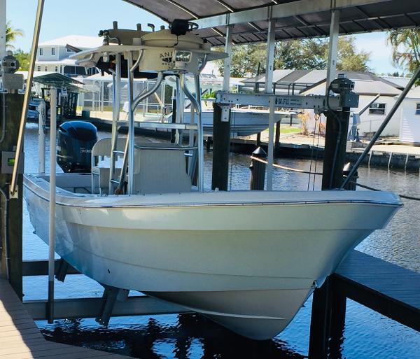 A 2011 Andros 26 Tarpon boat is on a lift above the water. It features a T-top.