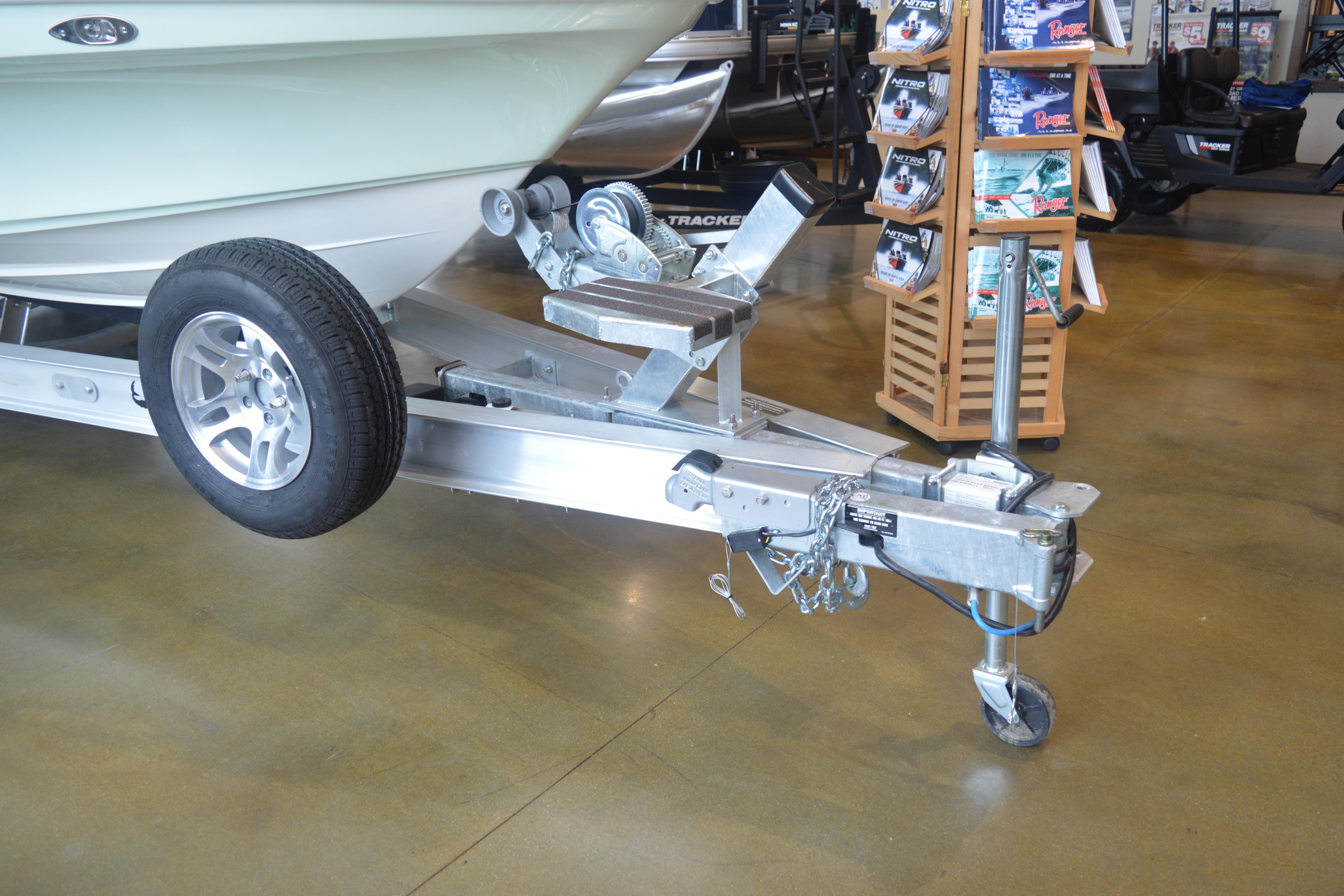 Trailer hitch of a 2026 Mako 24 APEX boat in showroom setting.