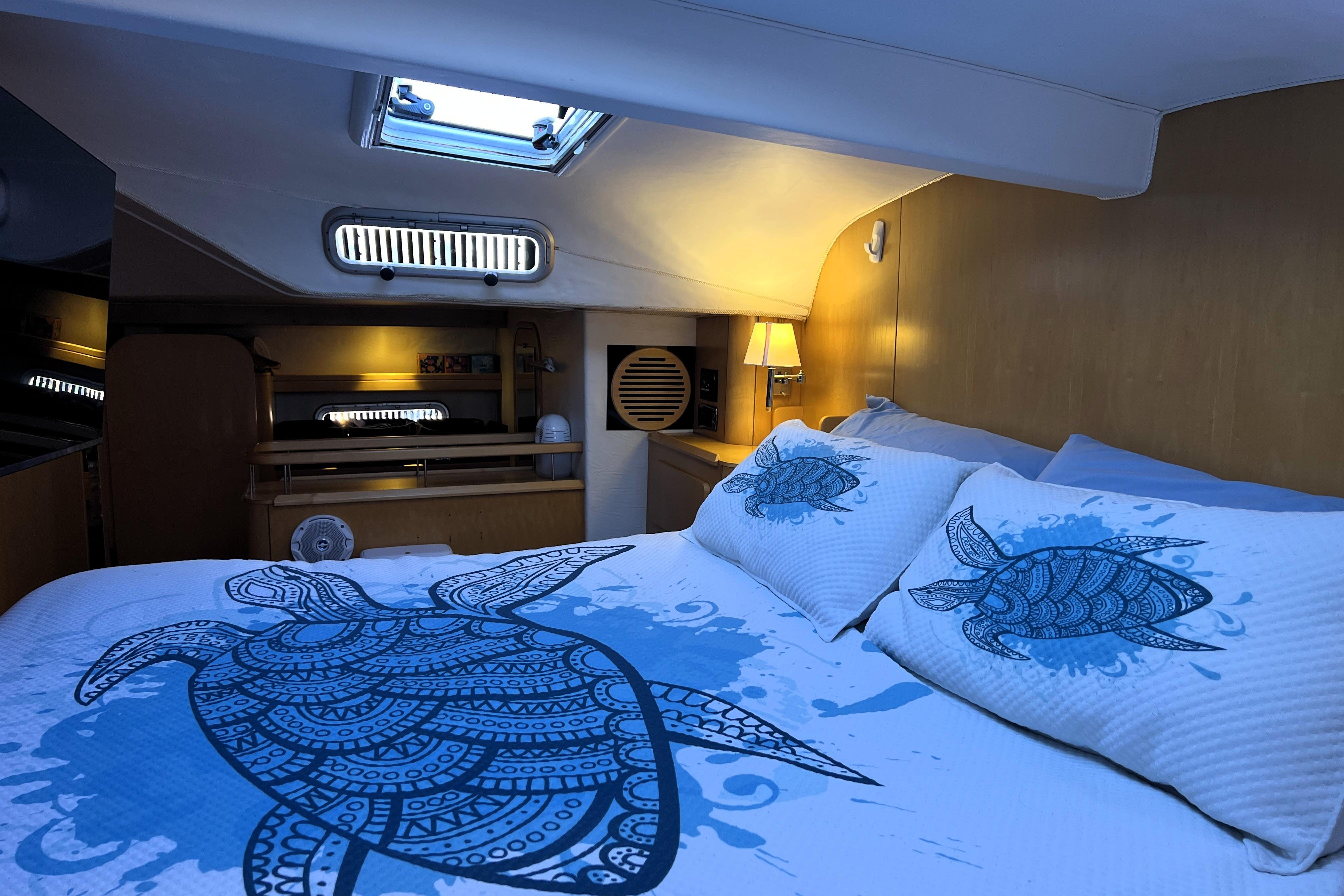Cozy cabin interior of 2011 Privilege 495 yacht with turtle-themed bedding.