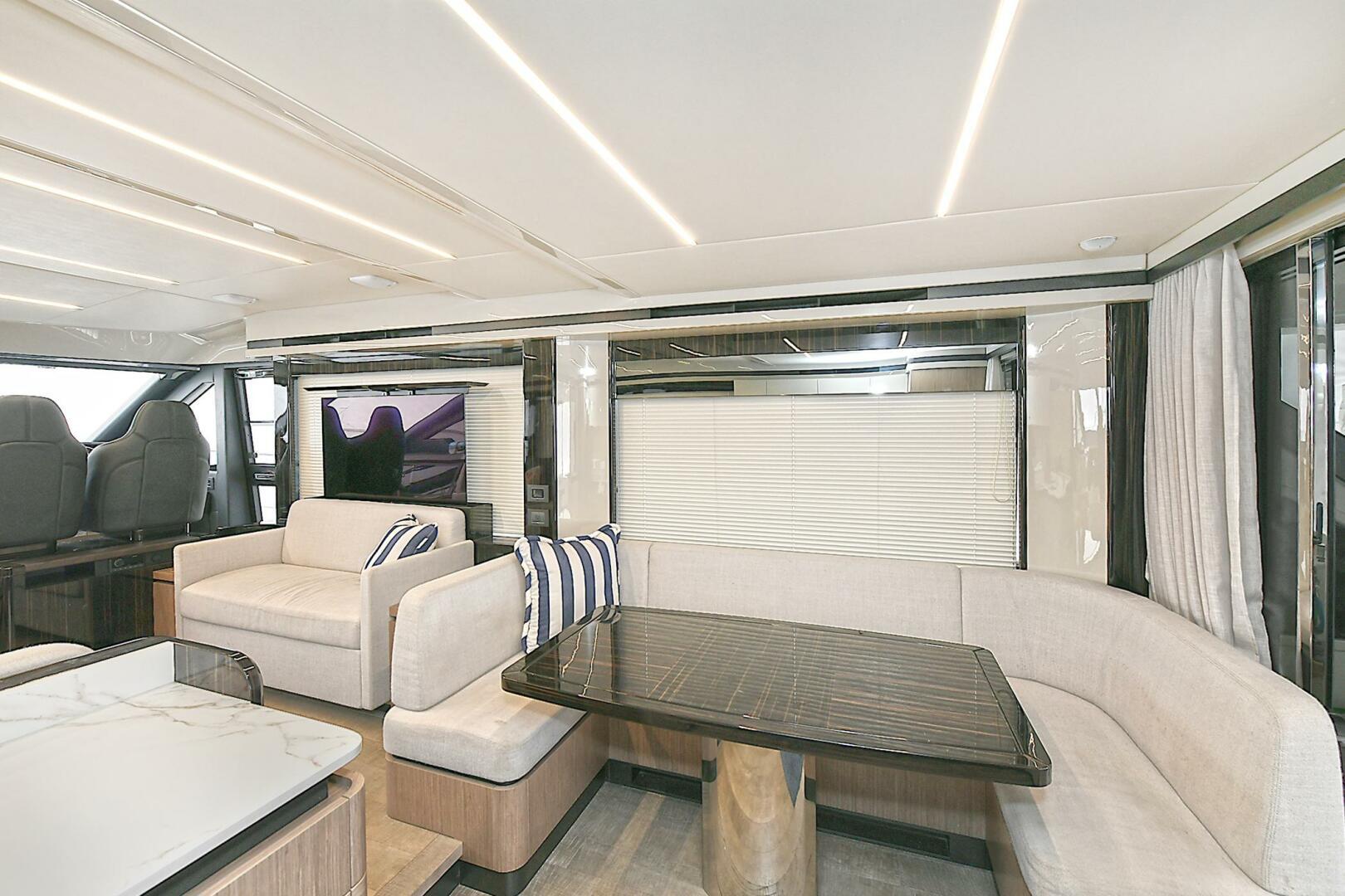 Luxurious interior of 2022 Absolute 62 Fly yacht with modern seating and dining area.