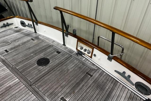 1984 Grand Banks Trawler deck with wooden railings and textured flooring.