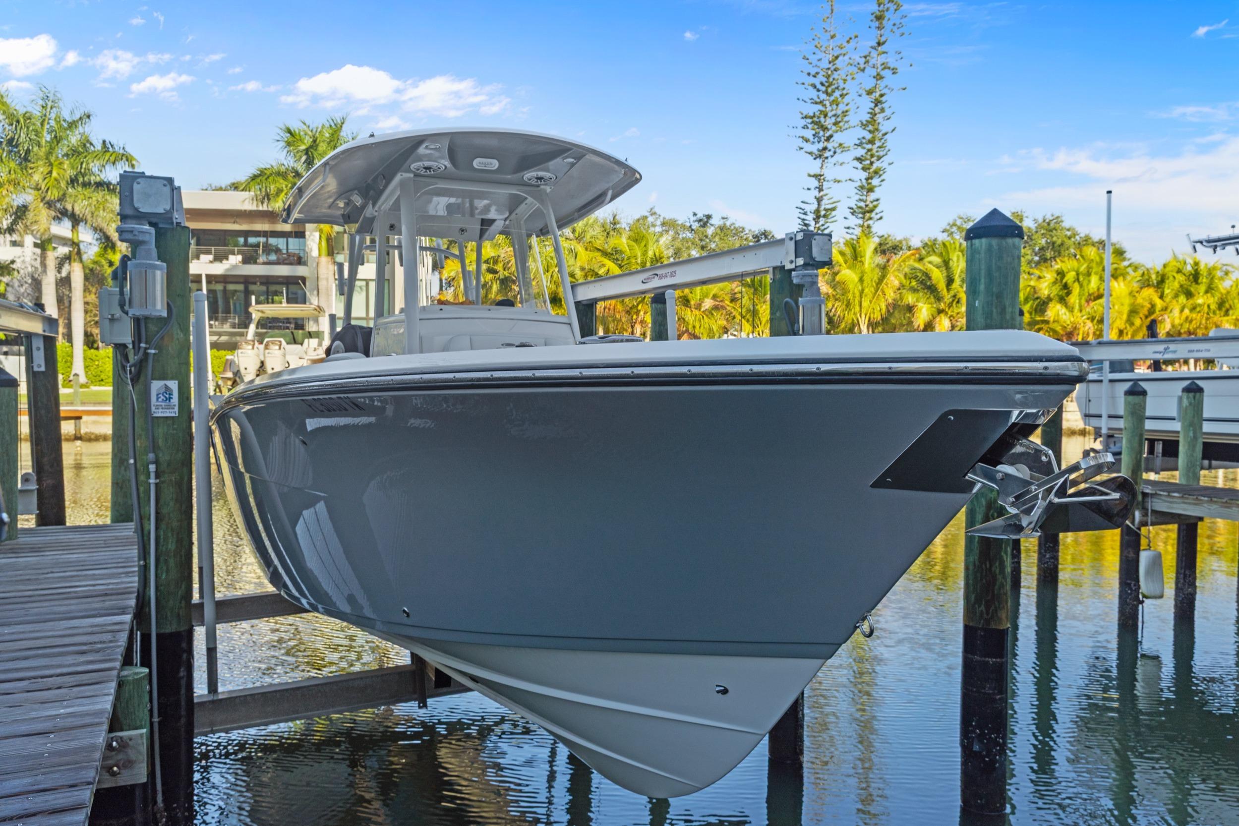2023 Cobia 301 Center Console boat docked in a sunny marina setting.