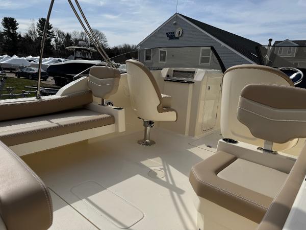 2025 Scout 215 Dorado boat interior with beige seating and helm, under a clear sky.