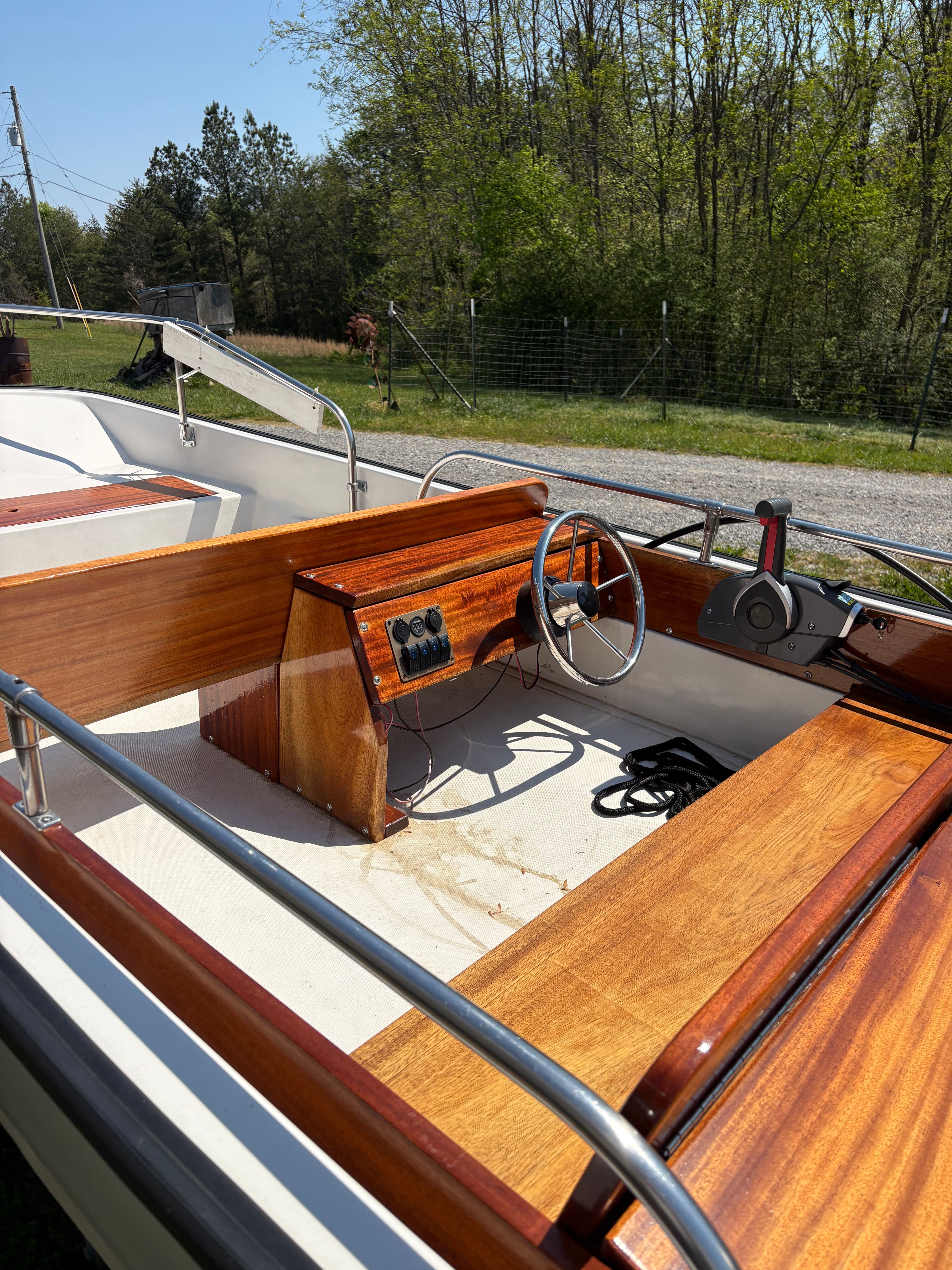 1977 Boston Whaler 13 with wooden interior and steering wheel outdoors.