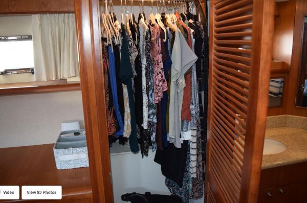Closet with clothes in 2002 Grand Alaskan Cockpit Motor Yacht interior.