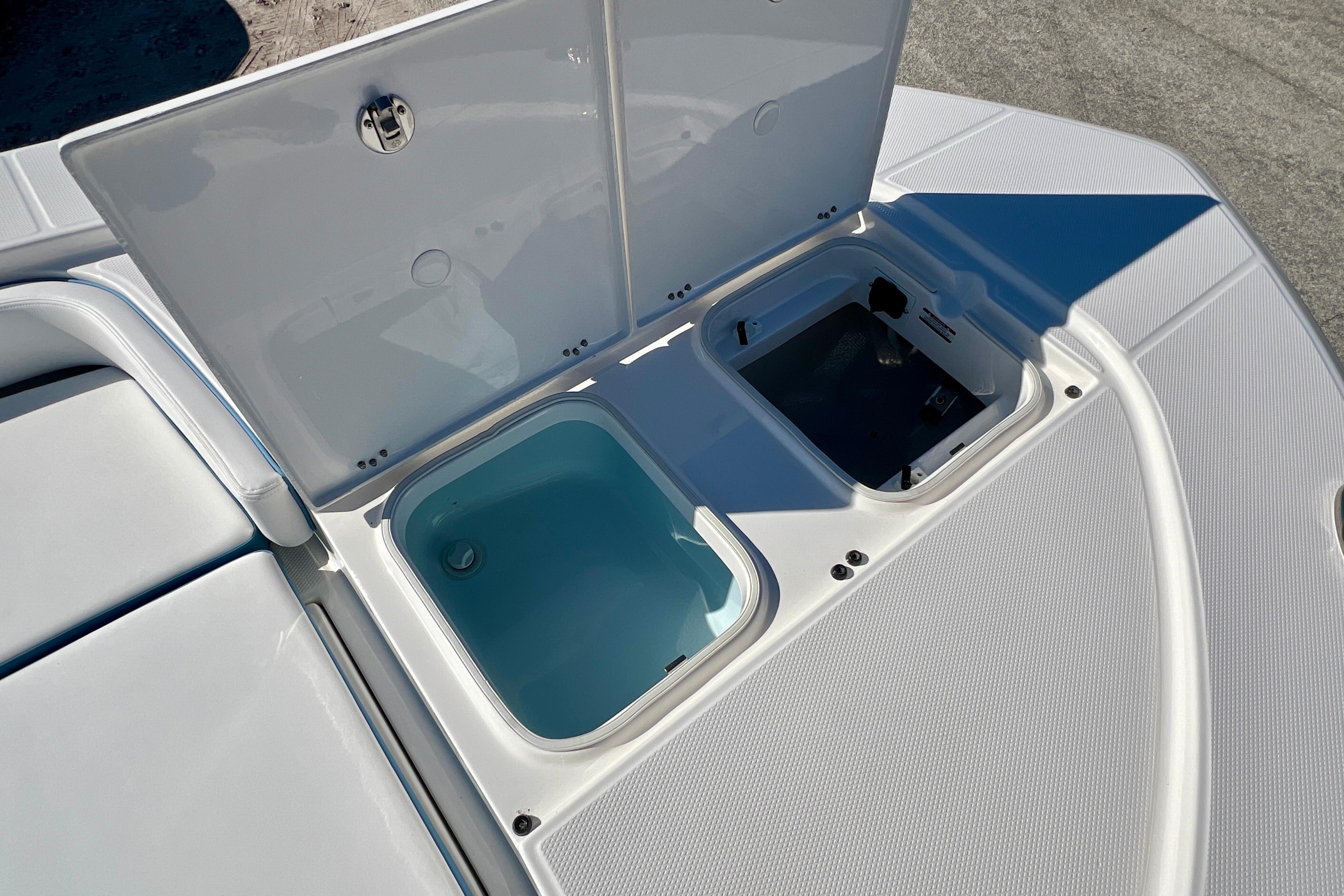 Open storage compartments on 2026 Robalo 246 Cayman boat deck.