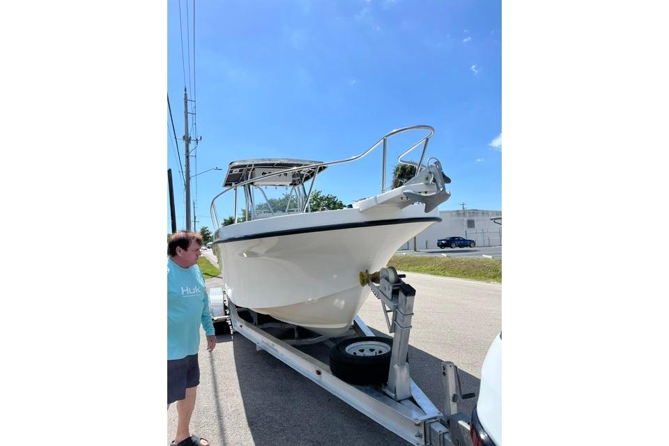 1999 Dusky 256 Center Console boat on trailer under clear blue sky.