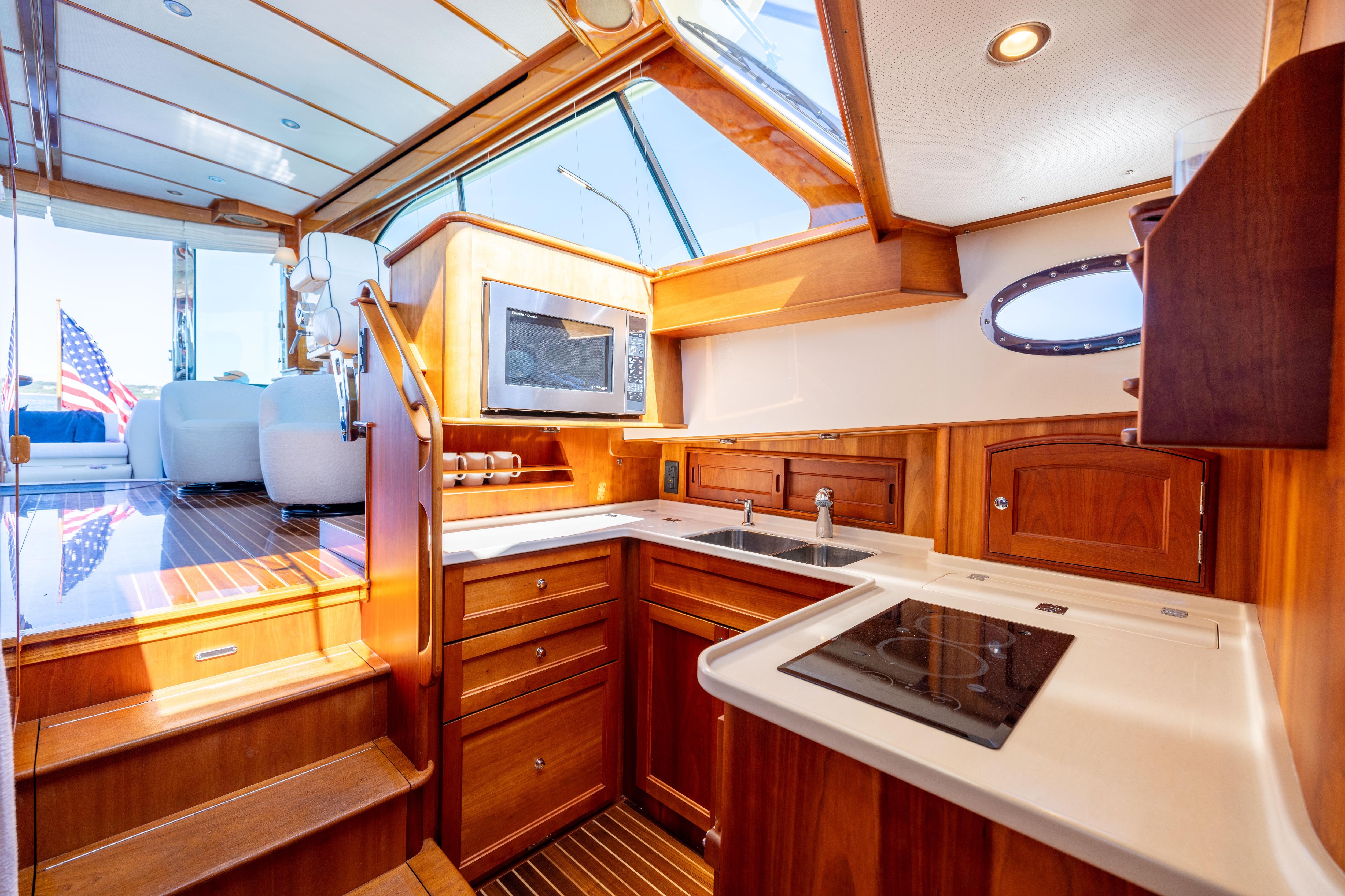 Luxurious 2014 Hinckley Talaria 48 Flybridge yacht interior with modern kitchen and wooden cabinetry.