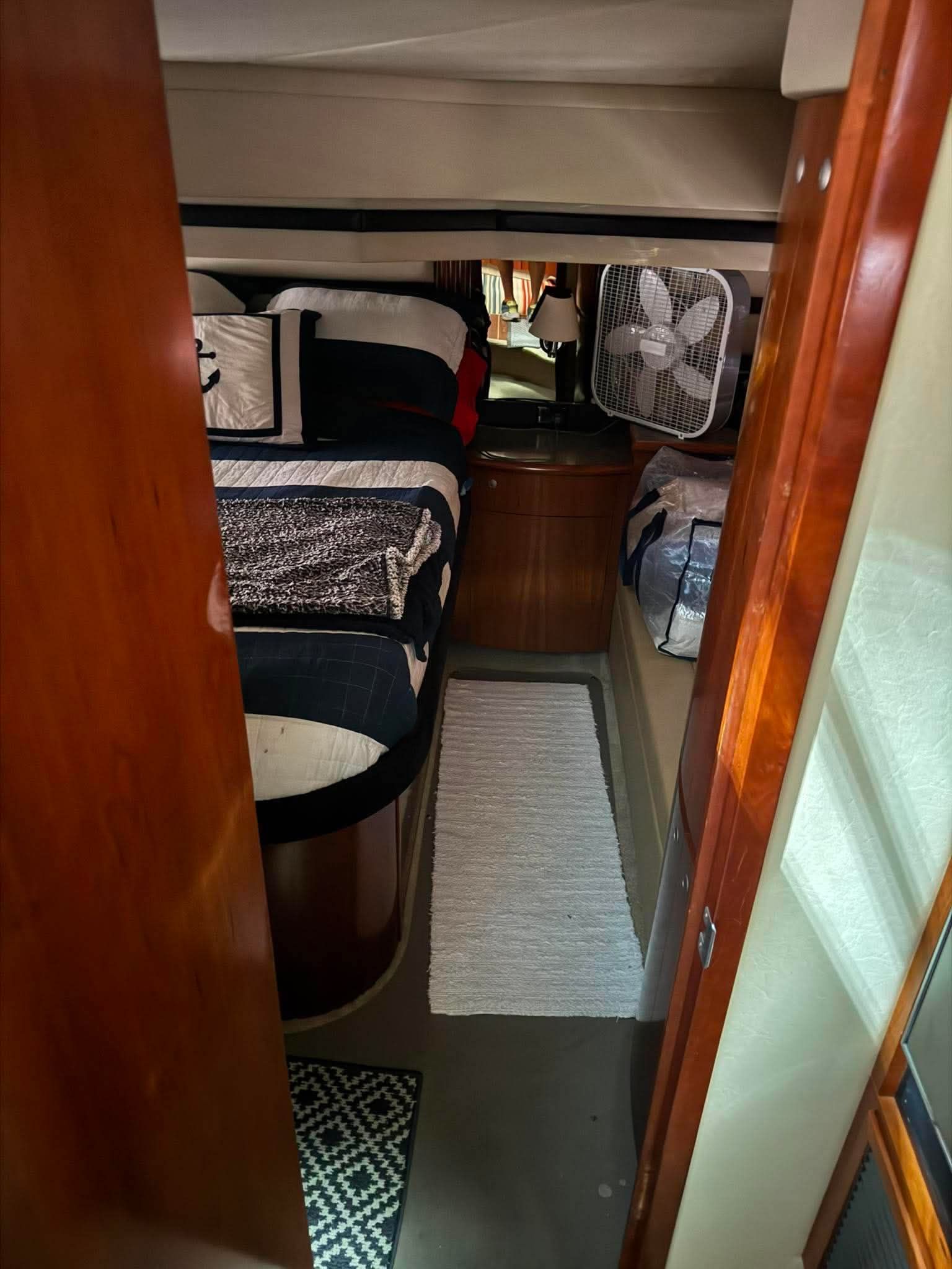Interior of a 2009 Cruisers Yachts 520 Sports Coupe with a cozy bed and fan.