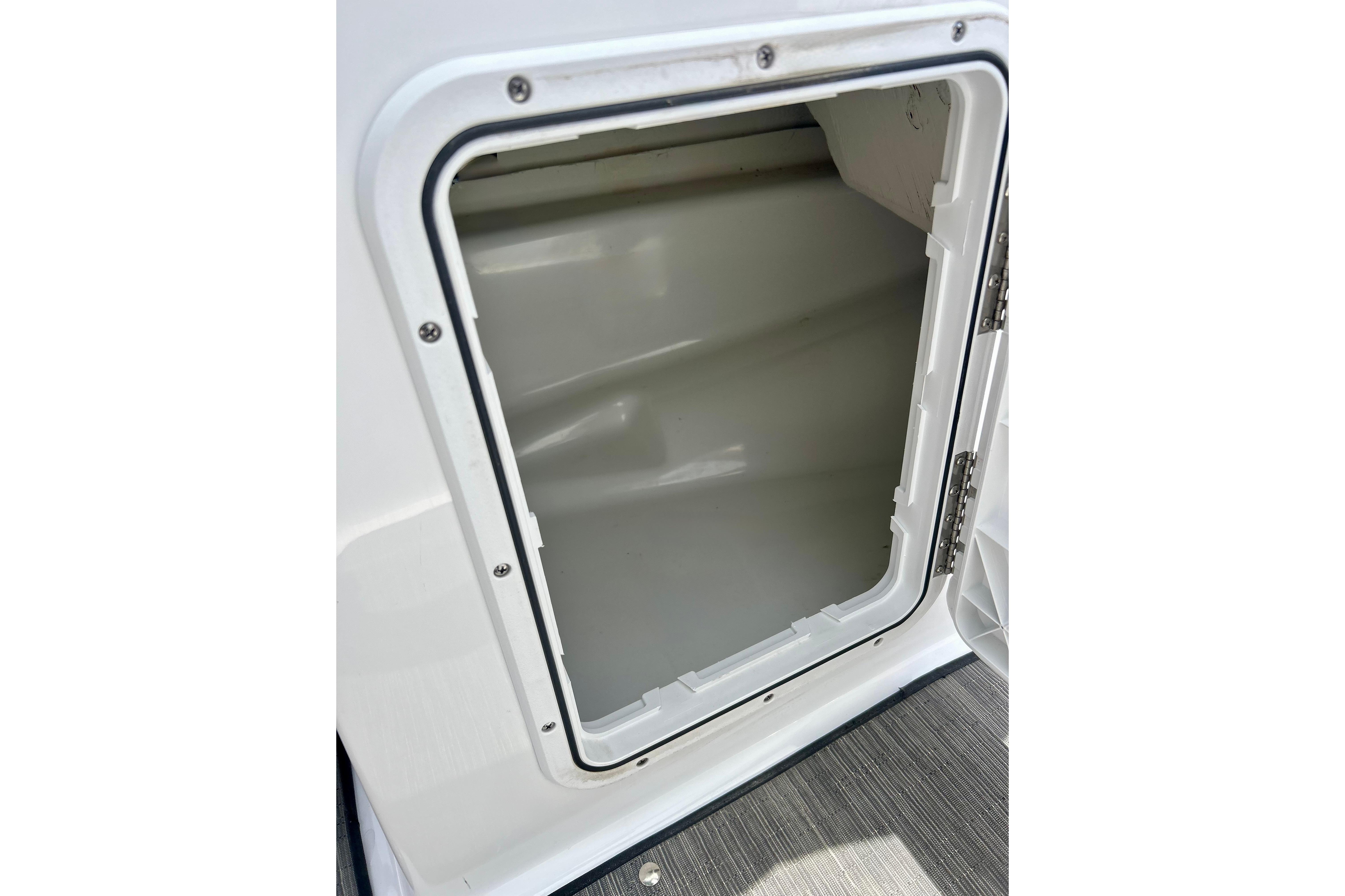 Open storage compartment on a 2021 Scarab 195 ID boat, showcasing interior space.