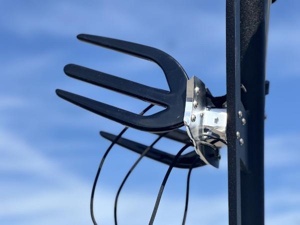 Antenna with prongs against blue sky, Axis A225 model, 2025.