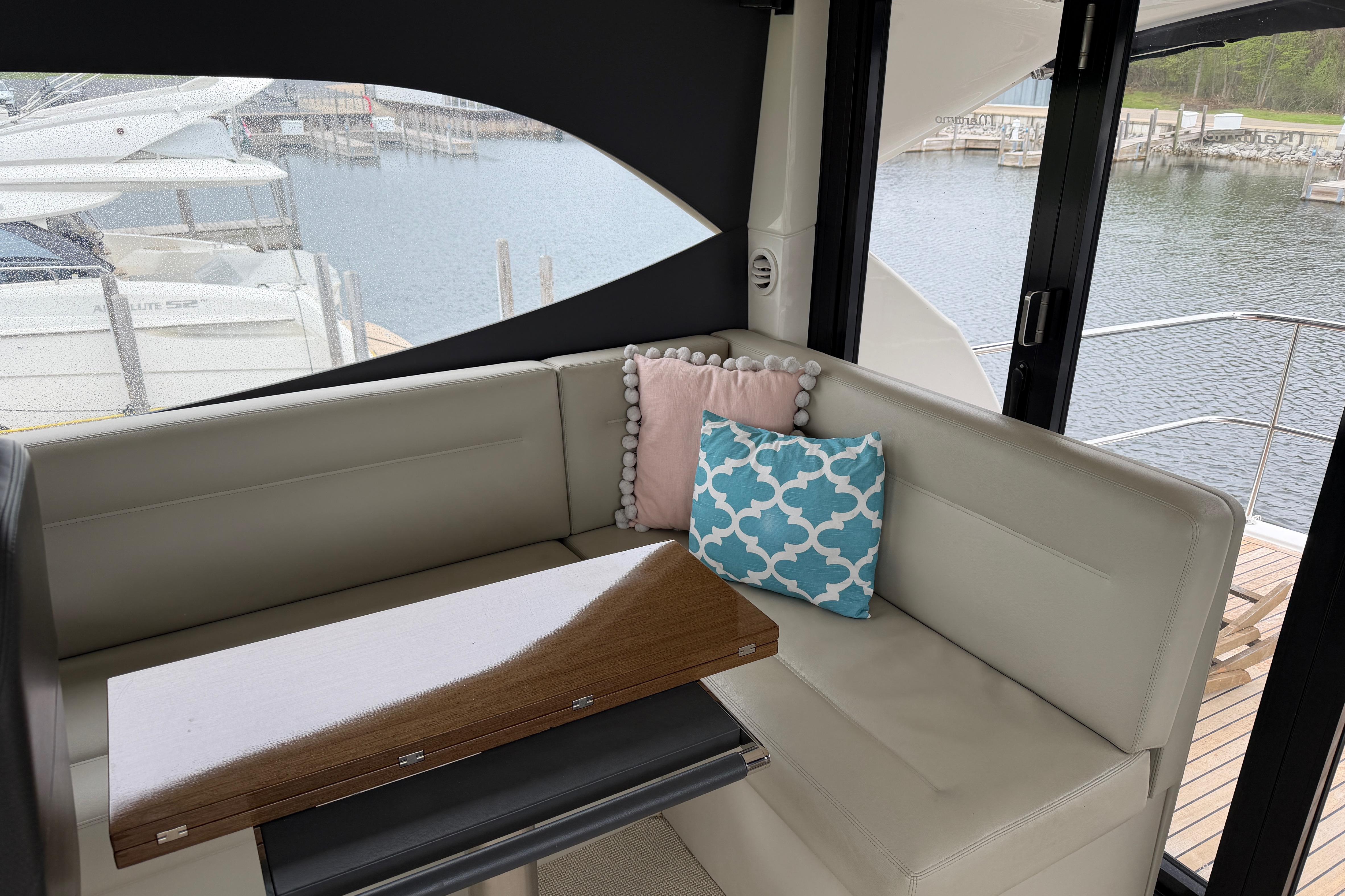 Interior of 2017 Maritimo M54 yacht with cozy seating and decorative pillows.