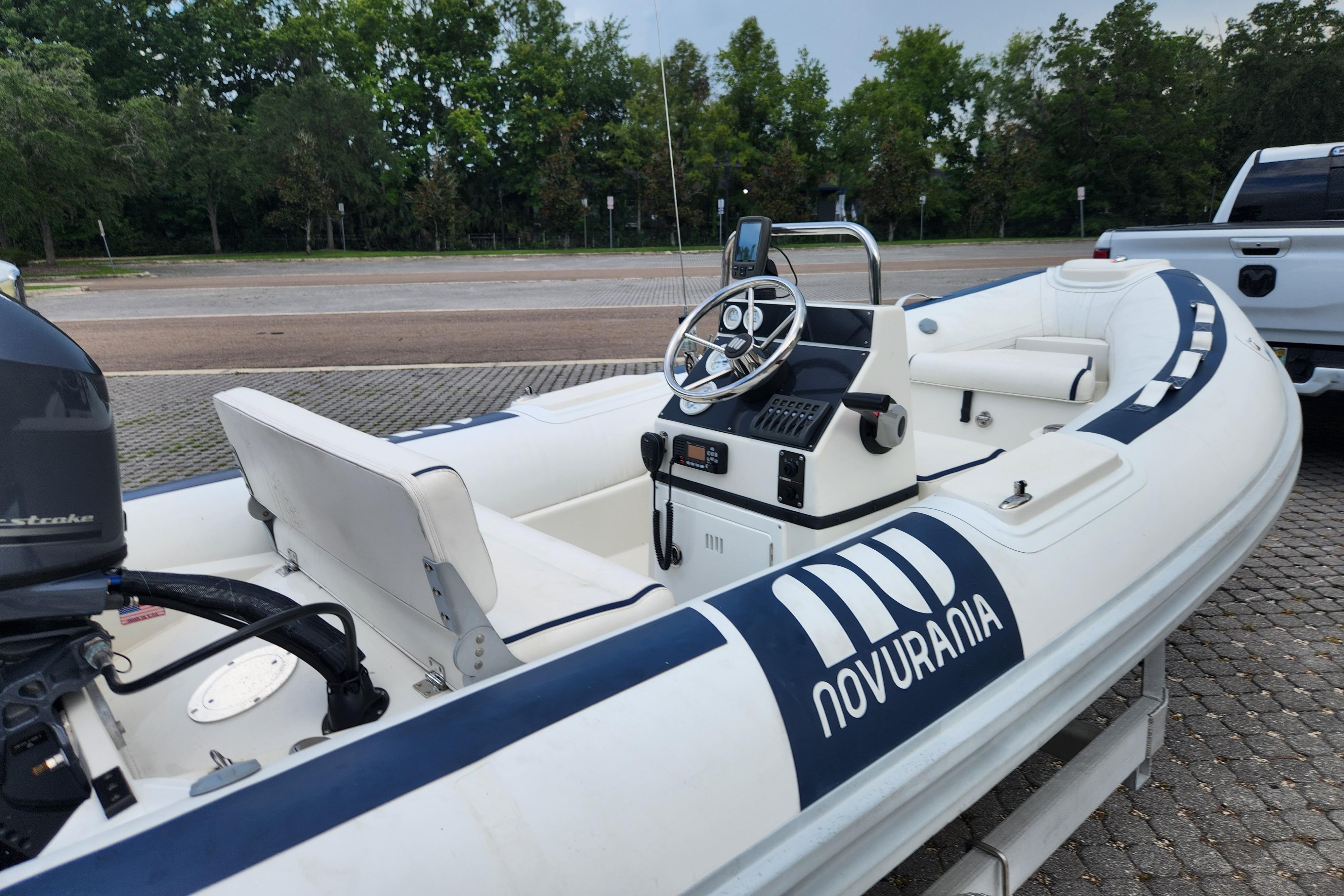 2019 Novurania DL 400 boat with steering console, parked on a paved area.