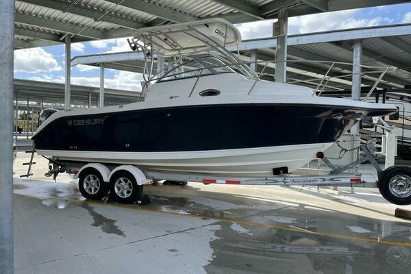 2006 Century 2400 Walk-Around boat on trailer in covered storage area.