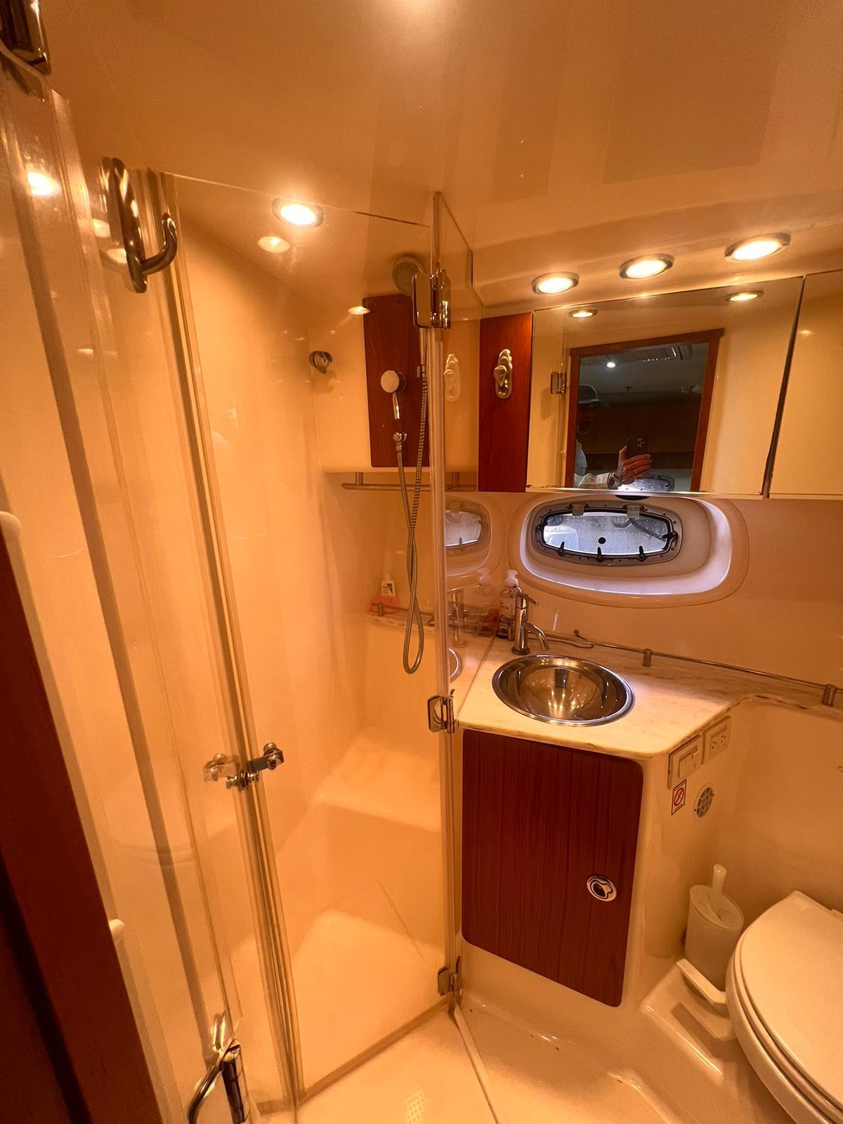 2014 Tiara Yachts 39 Coronet bathroom with shower, sink, and porthole window.