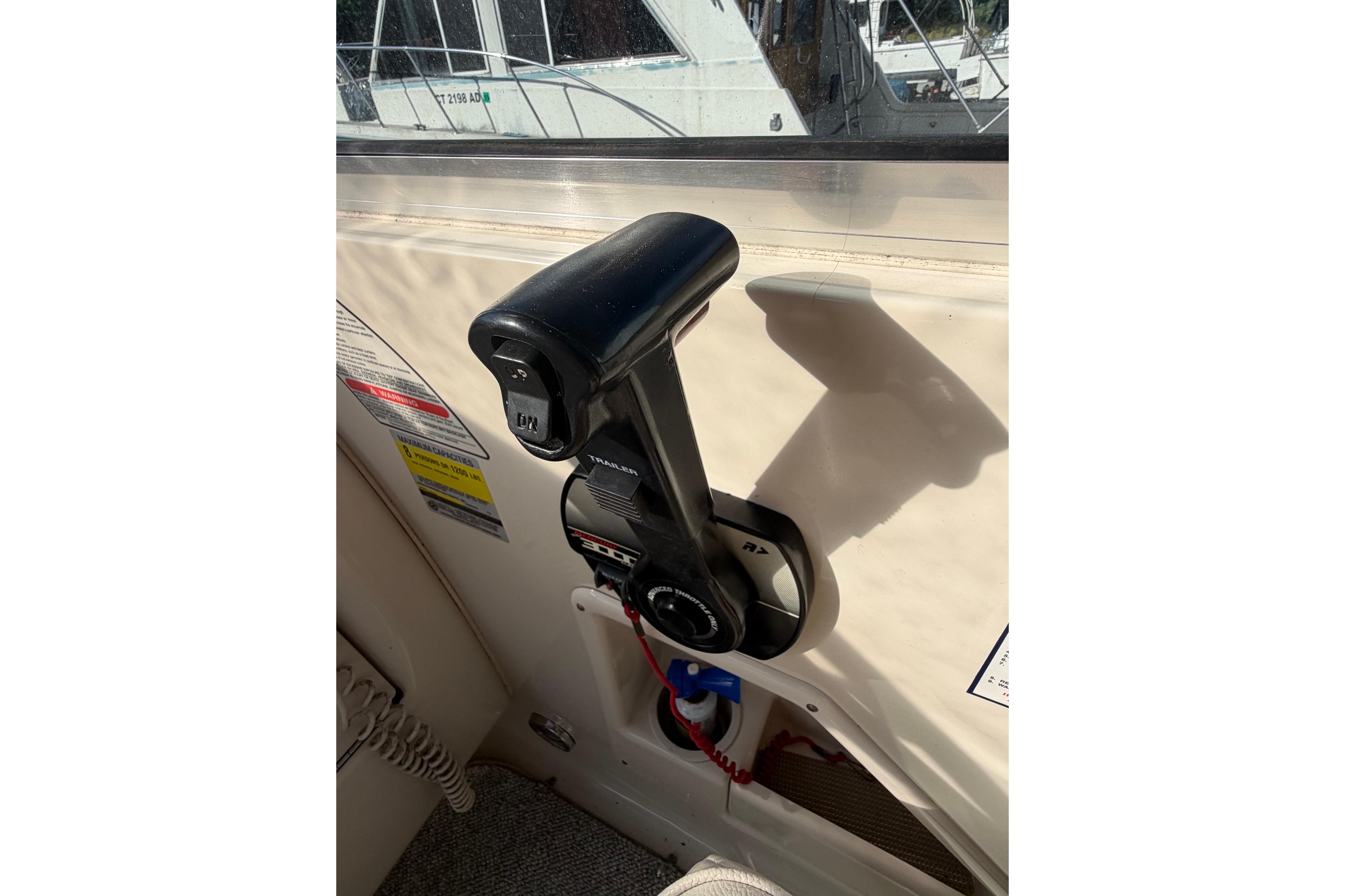 Throttle control of a 2000 Sea Ray 240 Sundancer boat in cockpit area.
