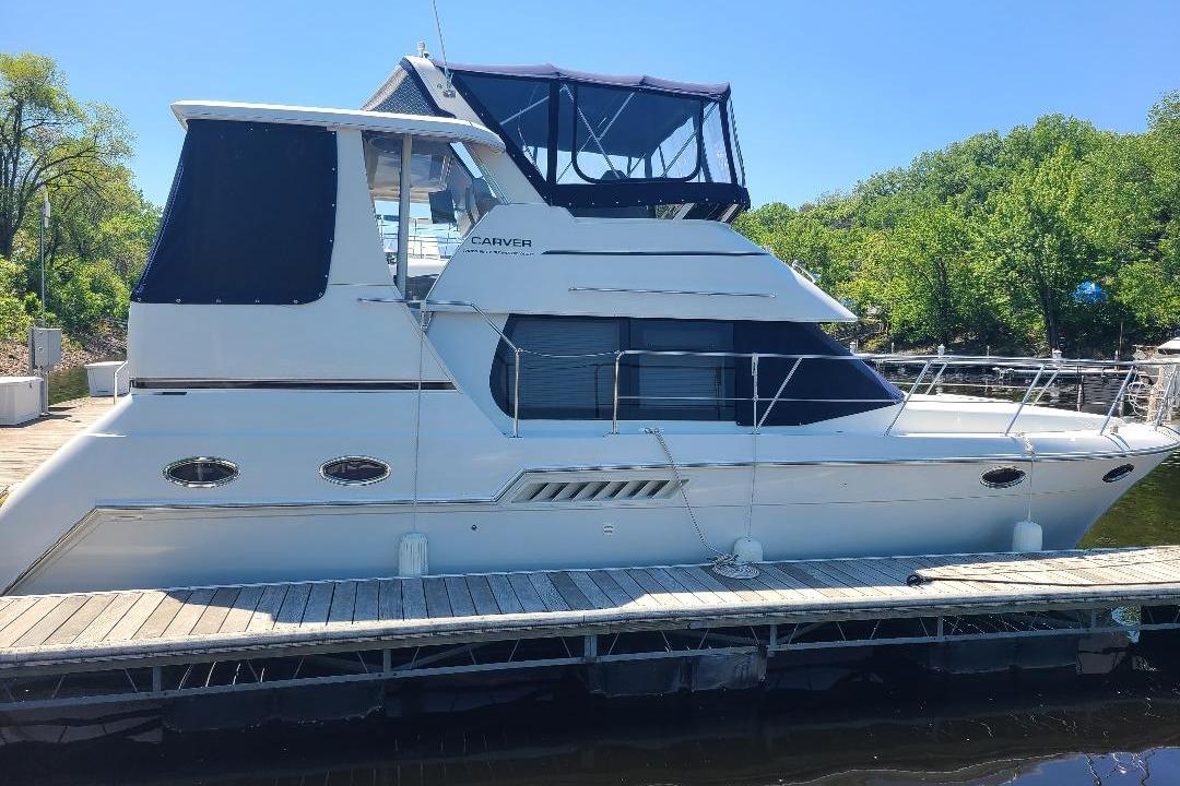 2003 Carver 356 Aft Cabin Motor Yacht docked, featuring sleek design and spacious cabin.
