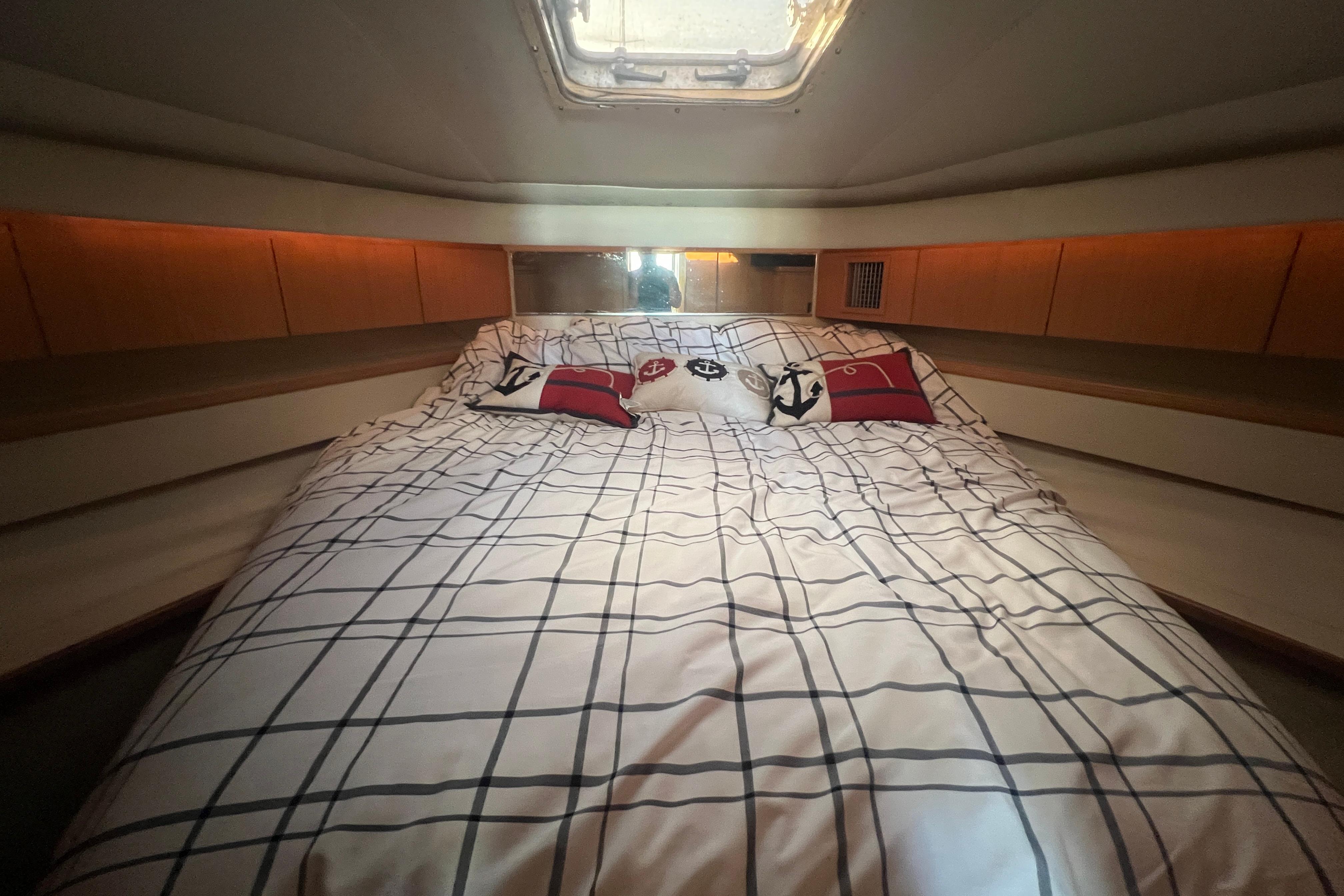 Cozy cabin interior of 1996 Tiara Yachts 4300 Open with nautical-themed bedding.