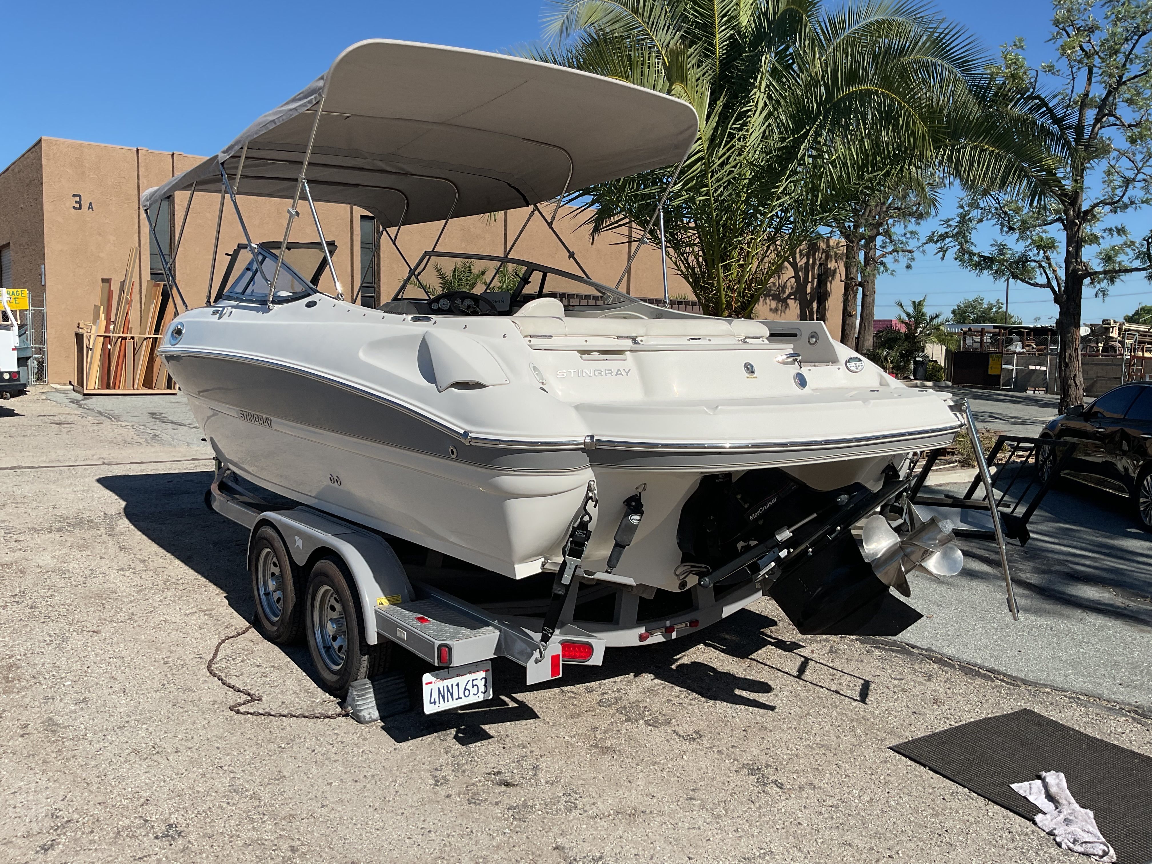 2011 Stingray 235 LR boat on trailer, parked outdoors.