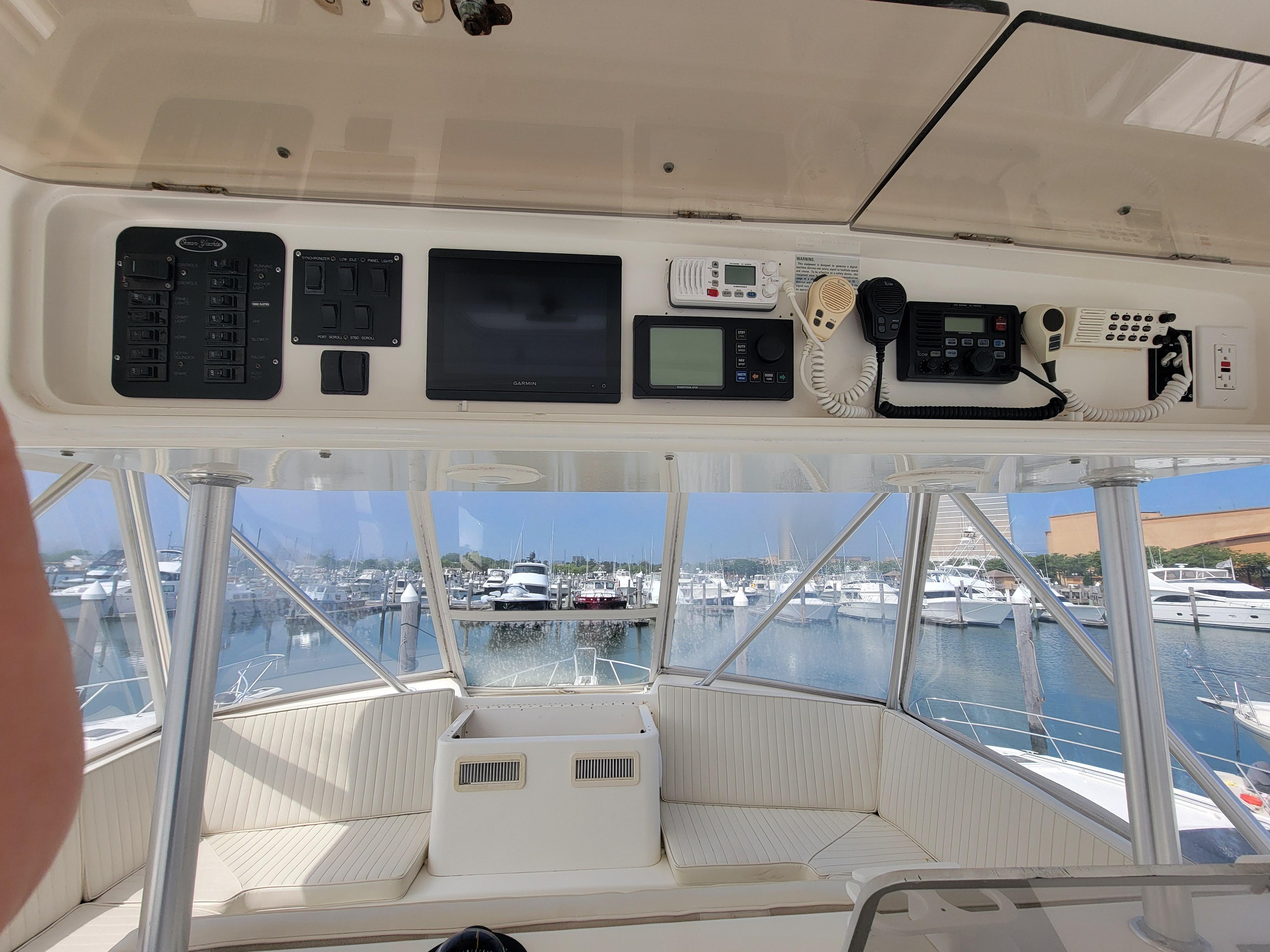 2001 Ocean Yachts 56 Super Sport helm with navigation equipment and marina view.