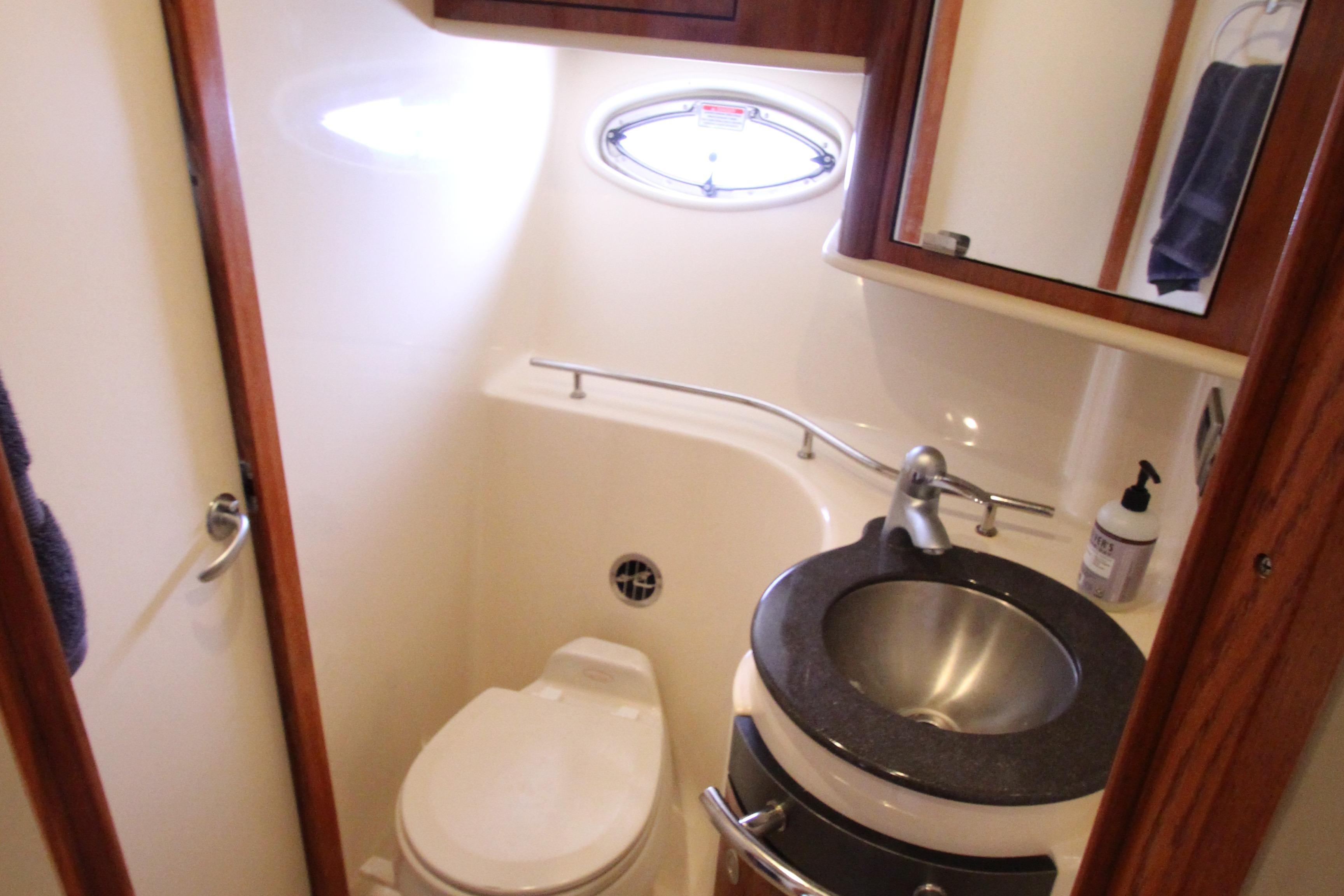 Compact bathroom in 2004 Sea Ray 40 Sundancer yacht with sink and toilet.
