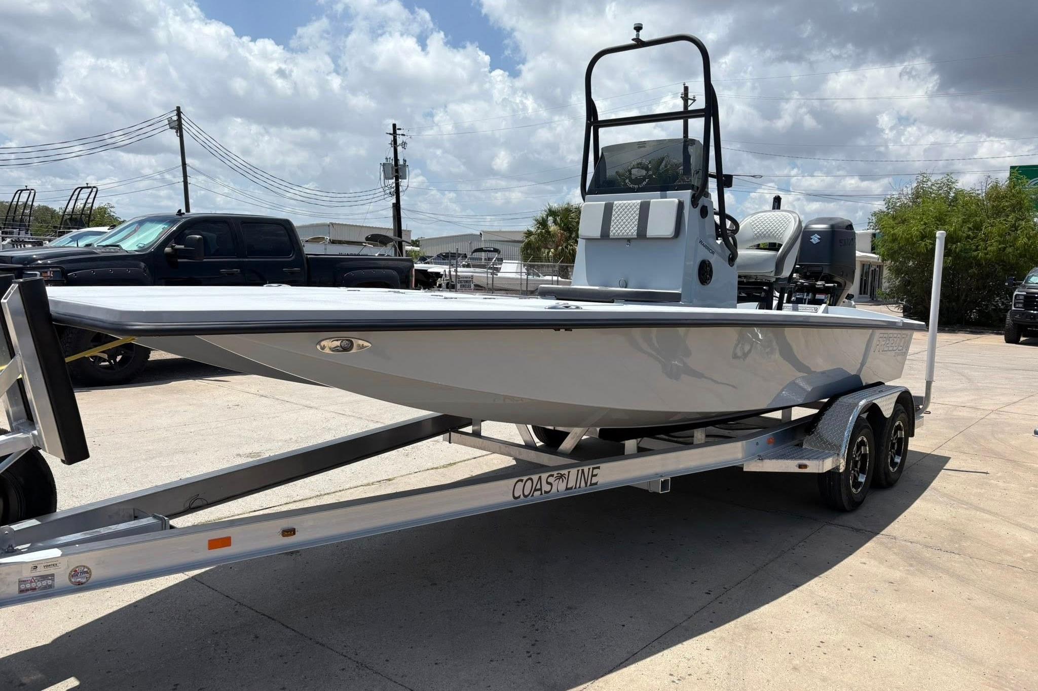 2026 Freedom Boats 23' Warrior on trailer, parked outdoors under cloudy sky.