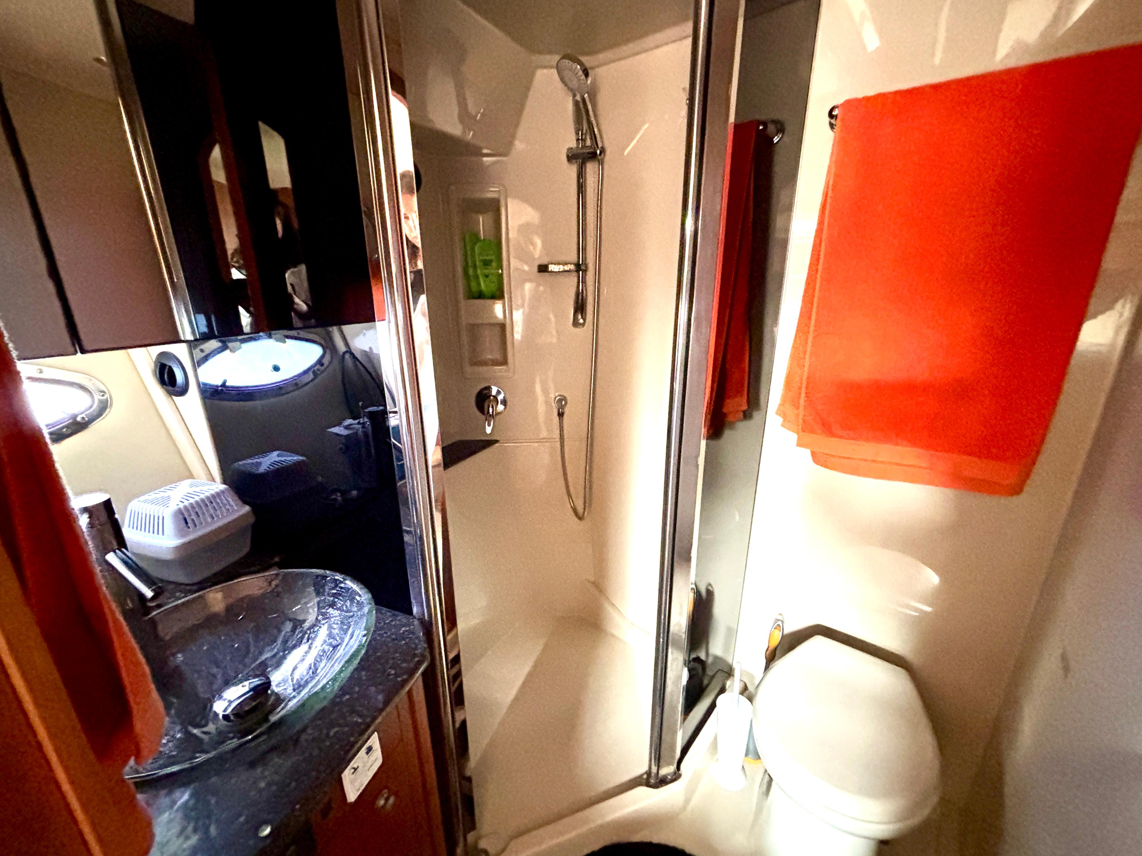 2007 Cruisers Yachts 447 Sport Sedan bathroom with shower, sink, and orange towel.