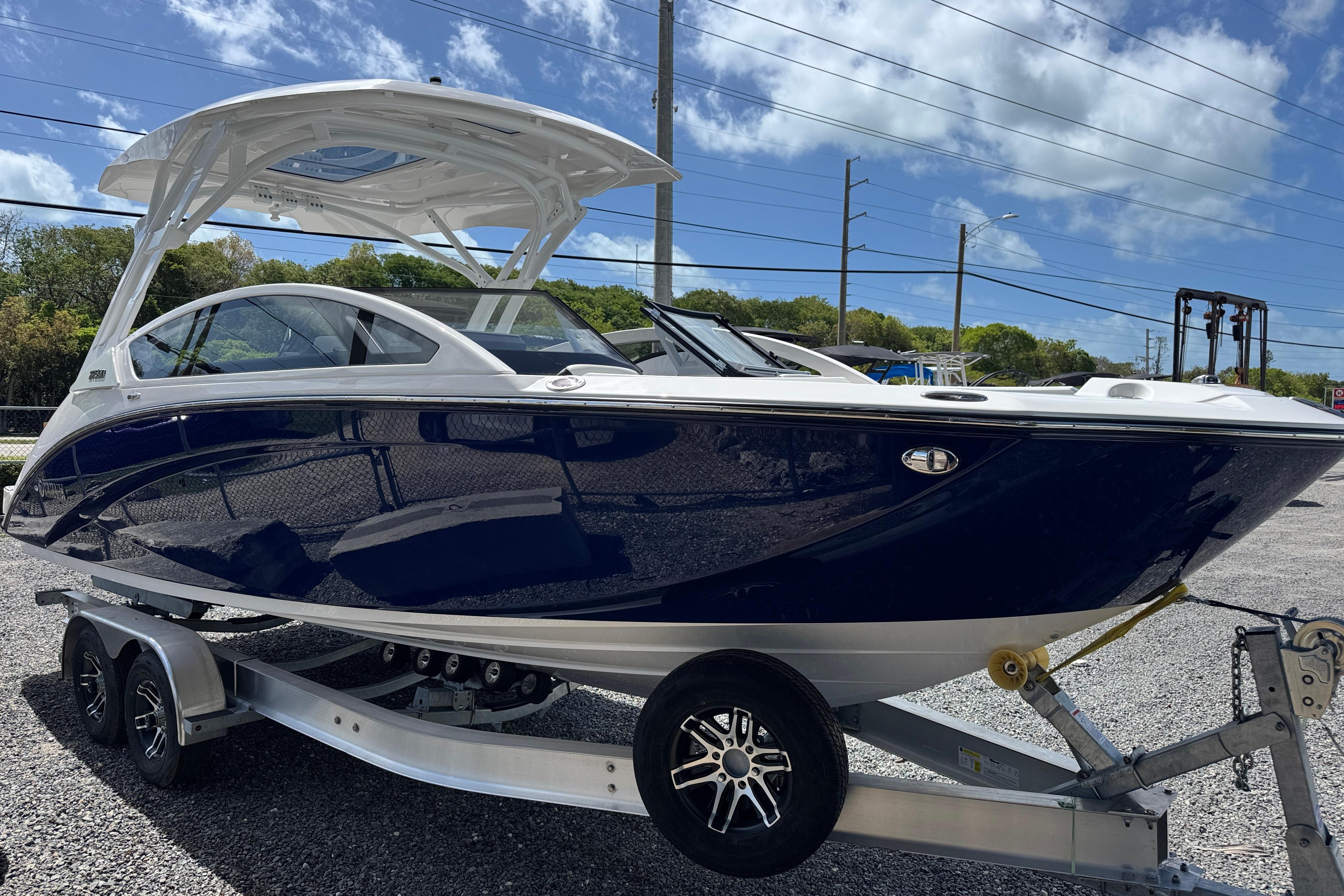 2026 Yamaha Boats 275SD on trailer, sleek design, blue hull, sunny day background.