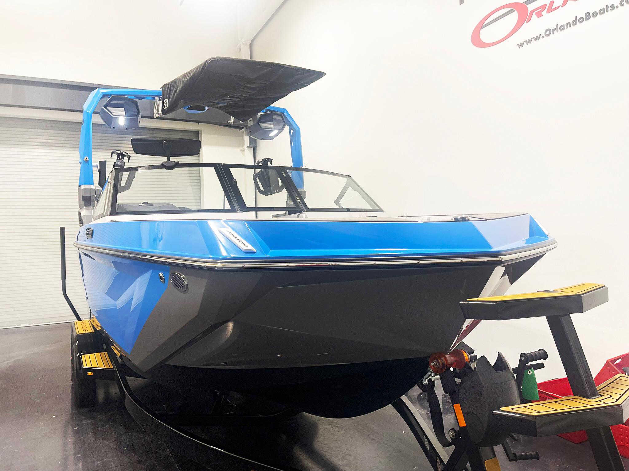 2025 Nautique Super Air Nautique GS24 boat in showroom, blue and gray design, on trailer.
