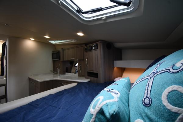 Interior of 2021 Regal 35 Sport Coupe with cozy bed and modern kitchenette.