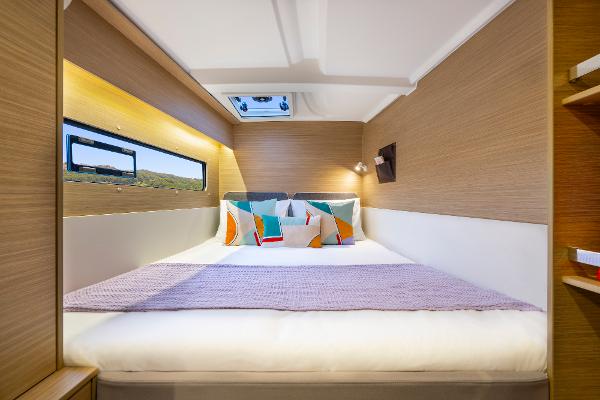 Luxurious cabin interior of 2025 Lagoon 38 yacht with modern bedding and natural light.