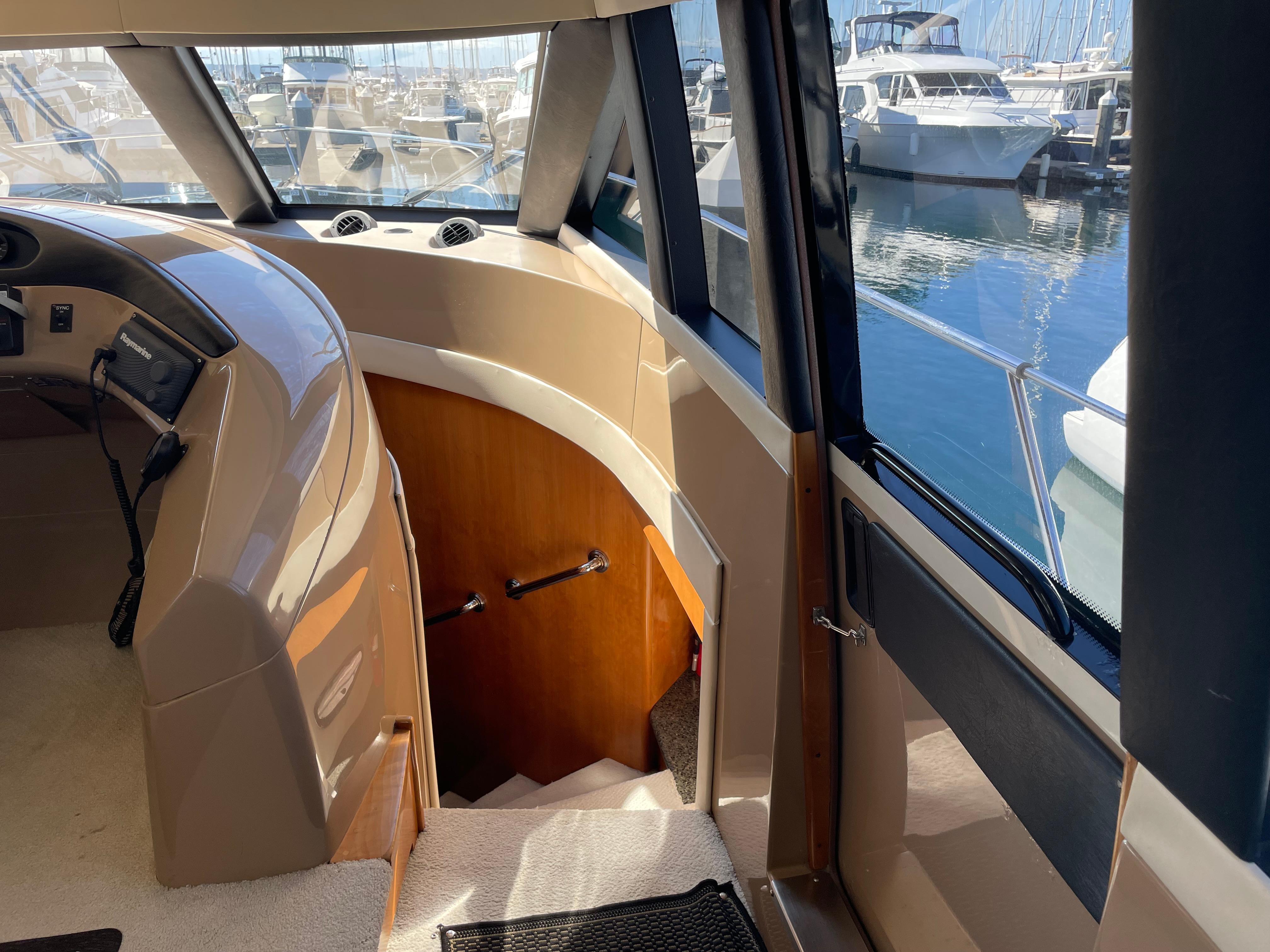 Interior view of 2000 Carver 530 Voyager Pilothouse, showcasing helm and staircase.