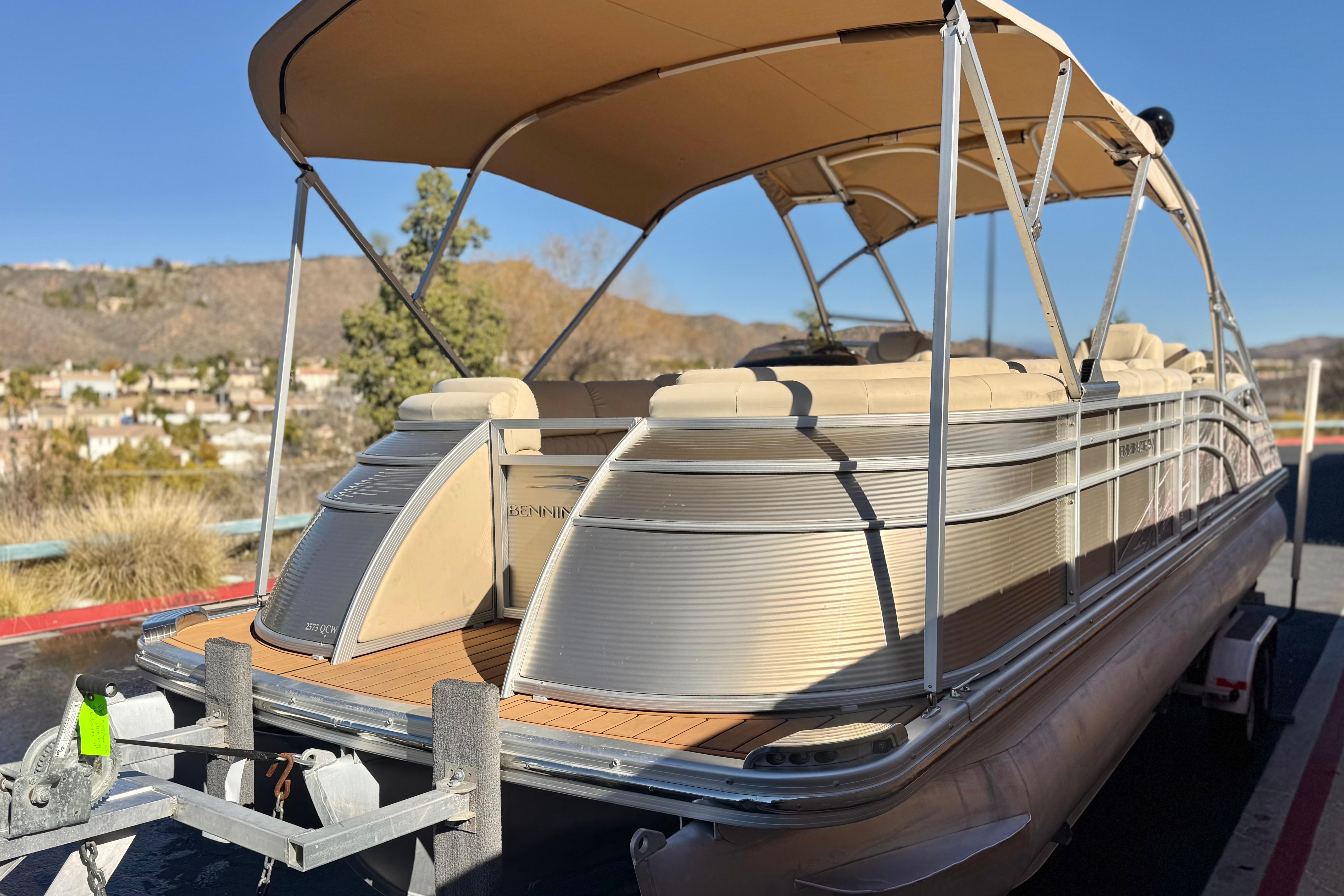 2013 Bennington 2575QCW I/O pontoon boat on trailer, scenic background.