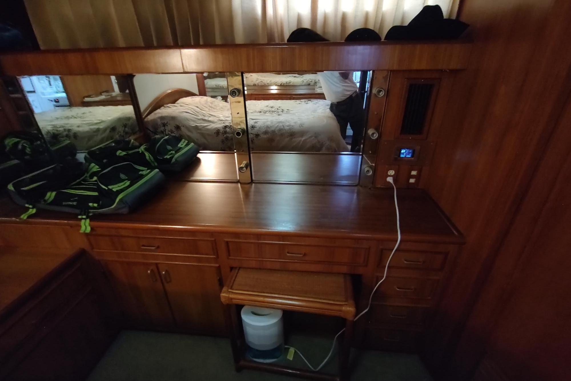 1989 Hyatt Double Cabin Motoryacht interior with wooden dresser and mirror.