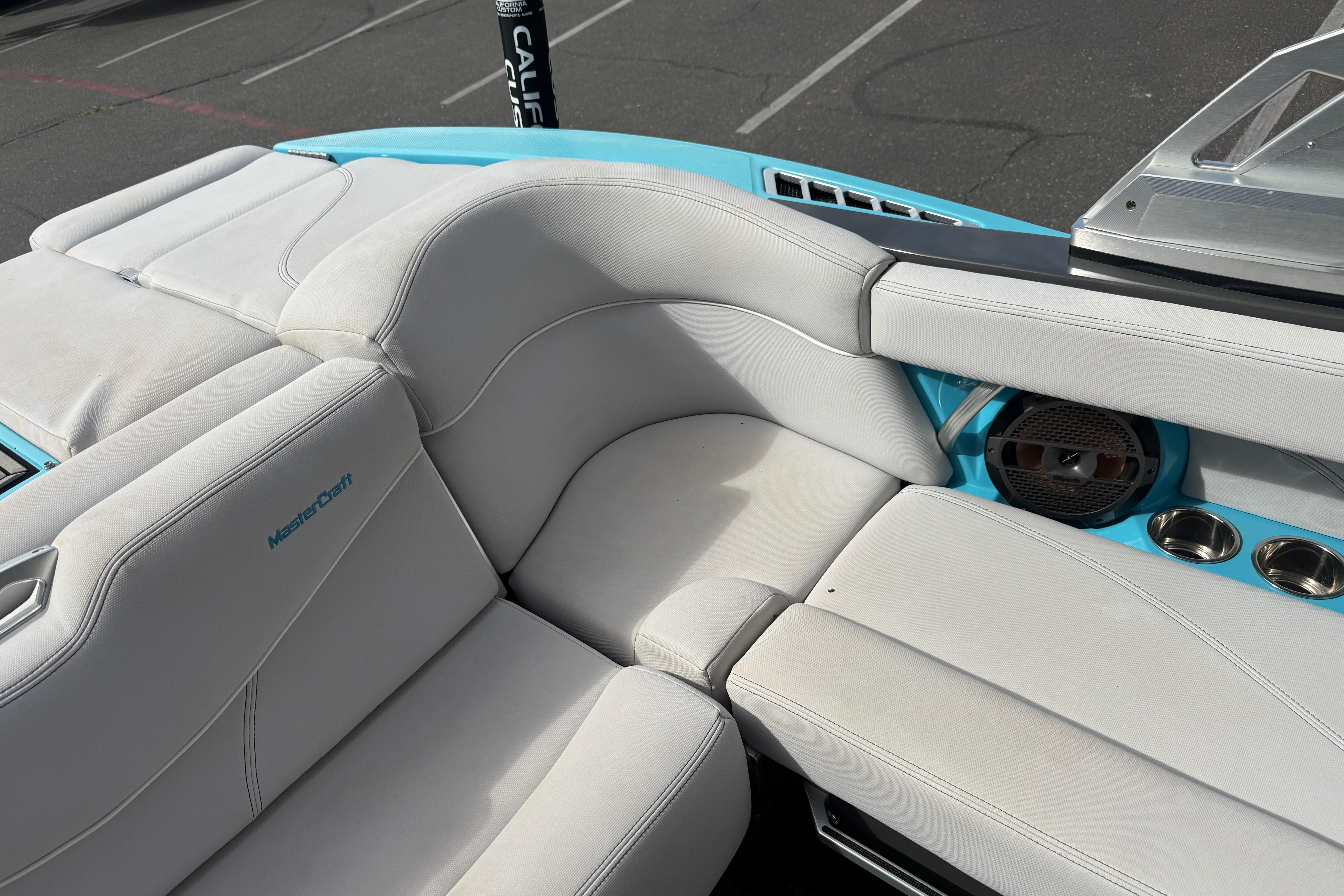 2018 MasterCraft XT21 boat interior with white and blue seating, cup holders, and speaker.