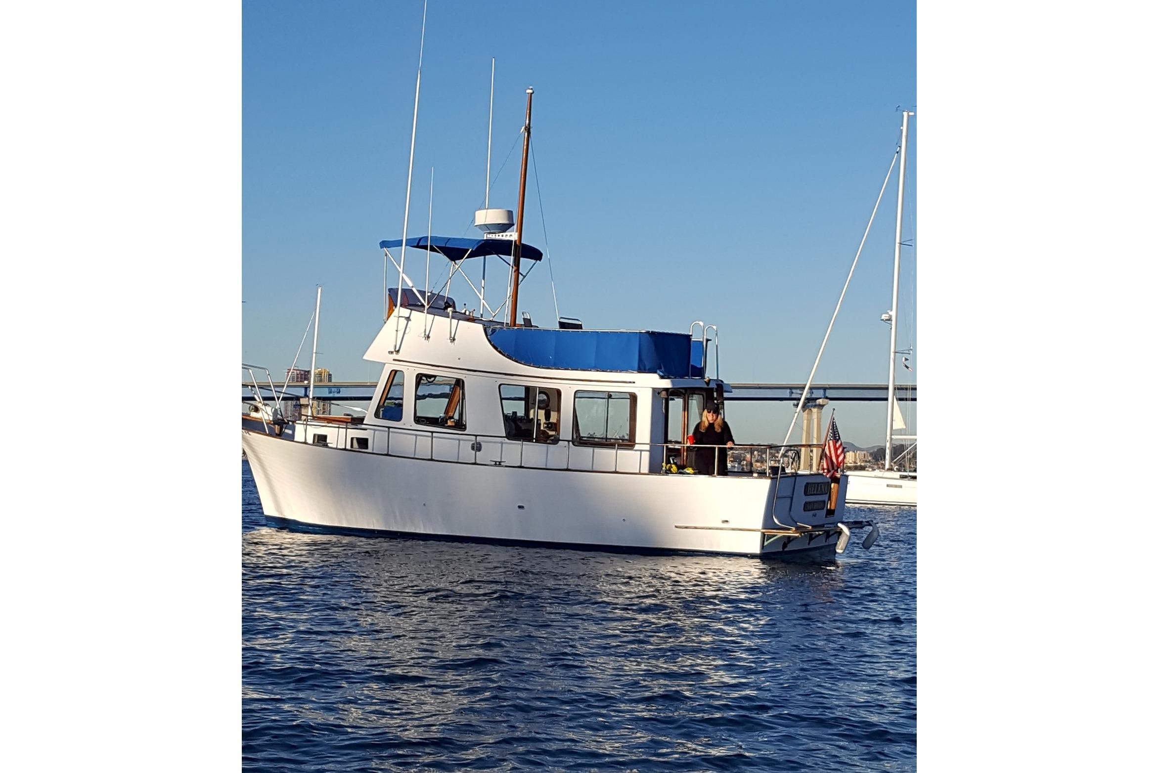 1973 CHB 33 boat on water, featuring blue canopy and American flag.