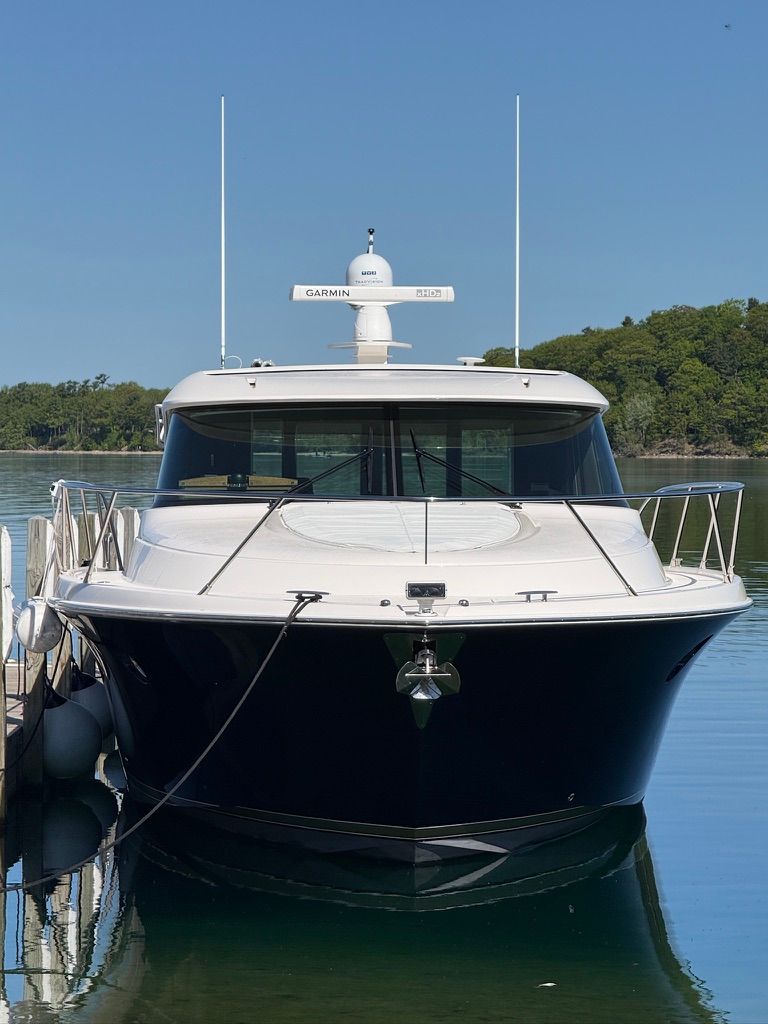 A 2017 Tiara Yachts C44 Coupe docked at a calm pier.