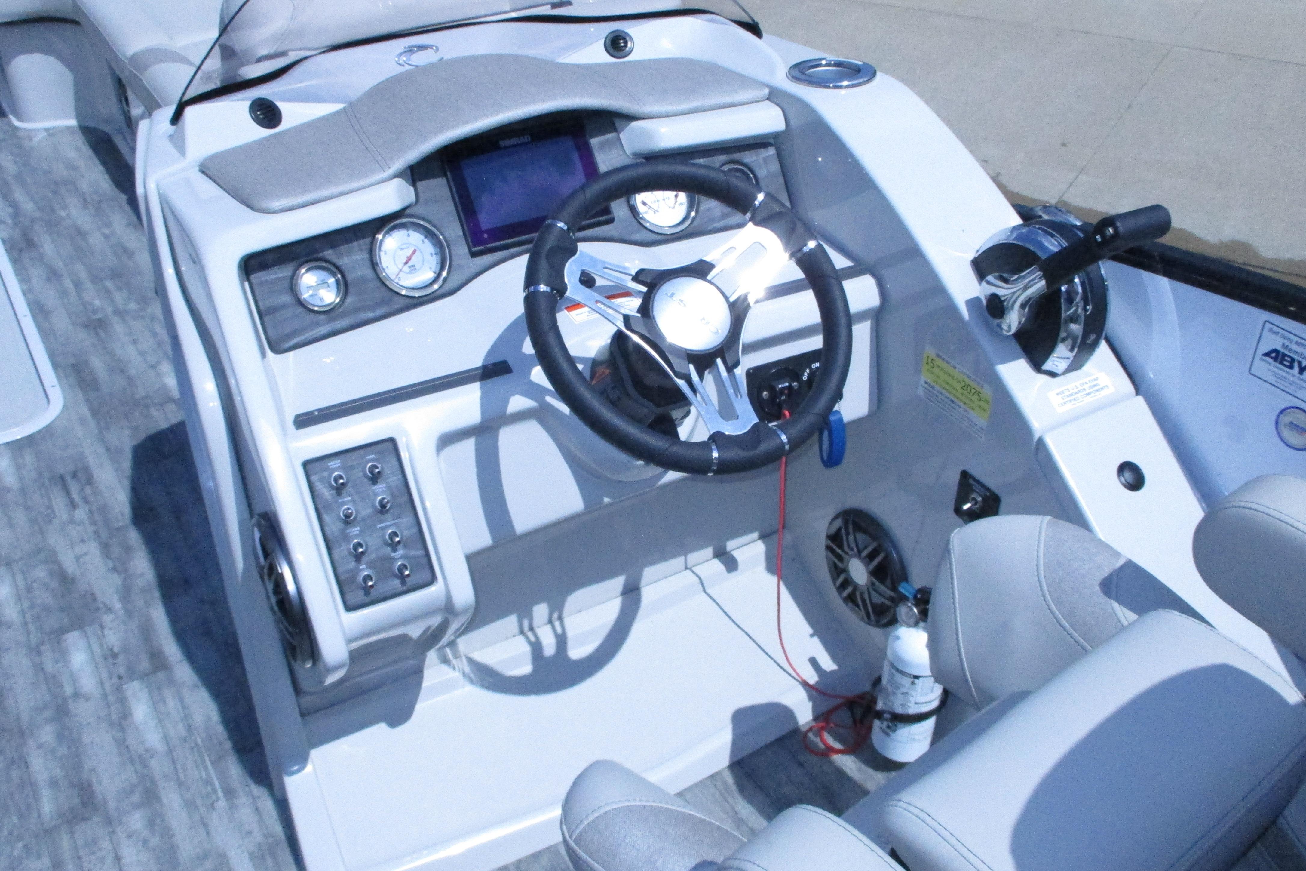Cockpit of 2021 Crest Caribbean LX 250 SLS boat with steering wheel and controls.