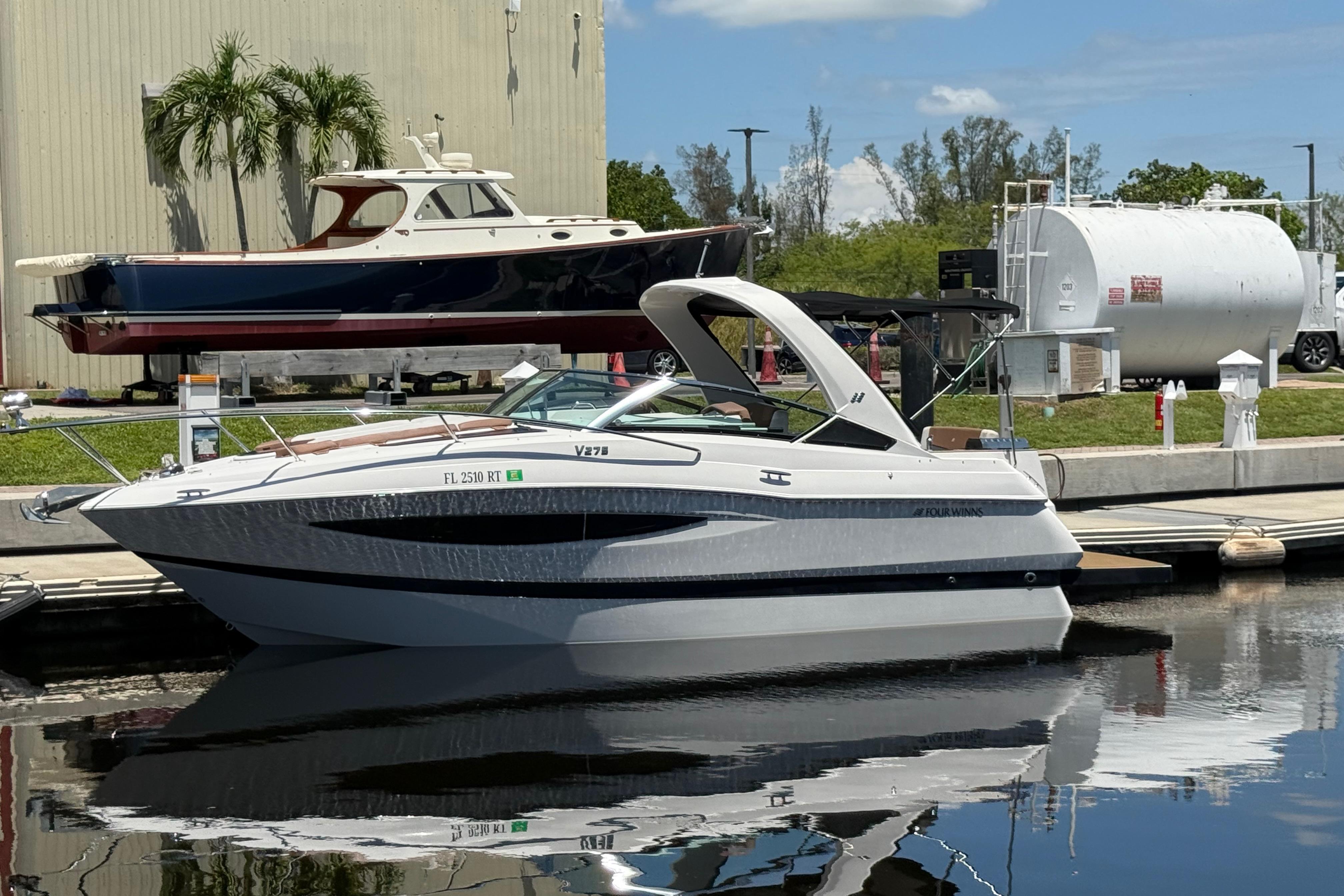2017 Four Winns V275 boat docked at marina under clear blue sky.